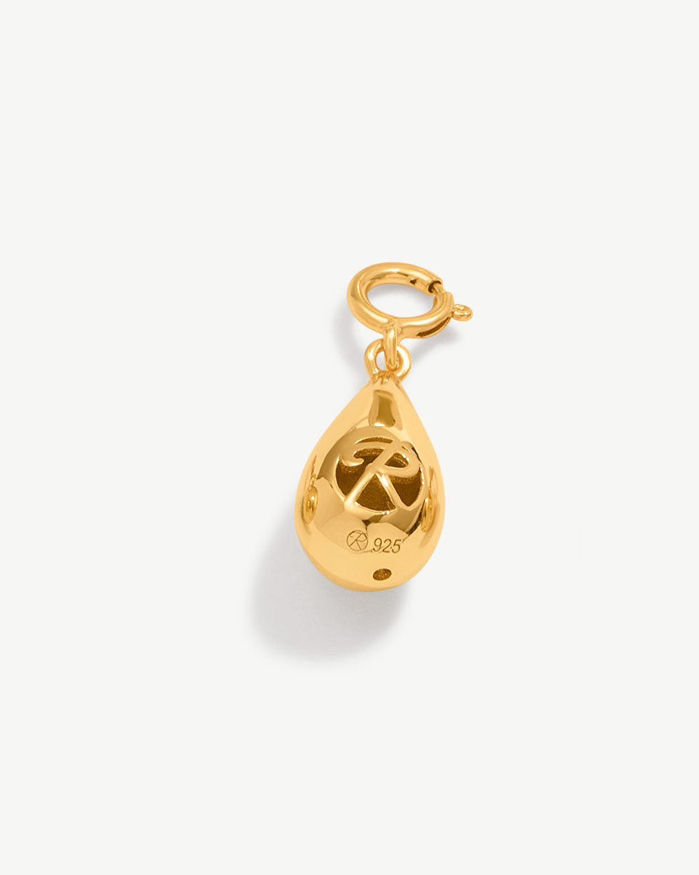 a gold charm with a peace sign on it