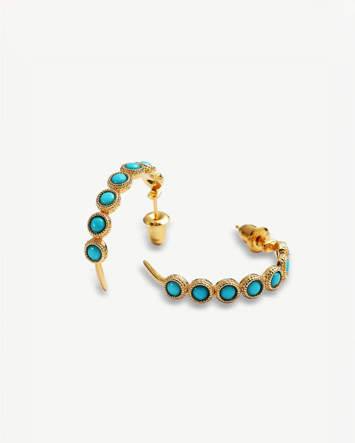 a pair of gold and turquoise stone earrings