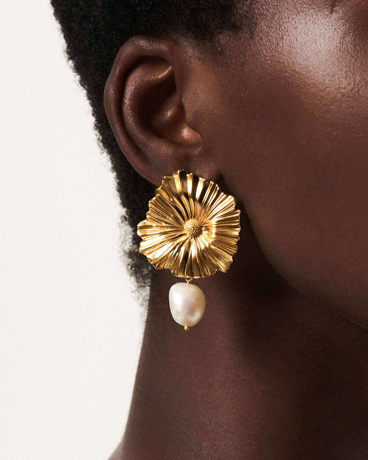 a close up of a person wearing a pair of earrings