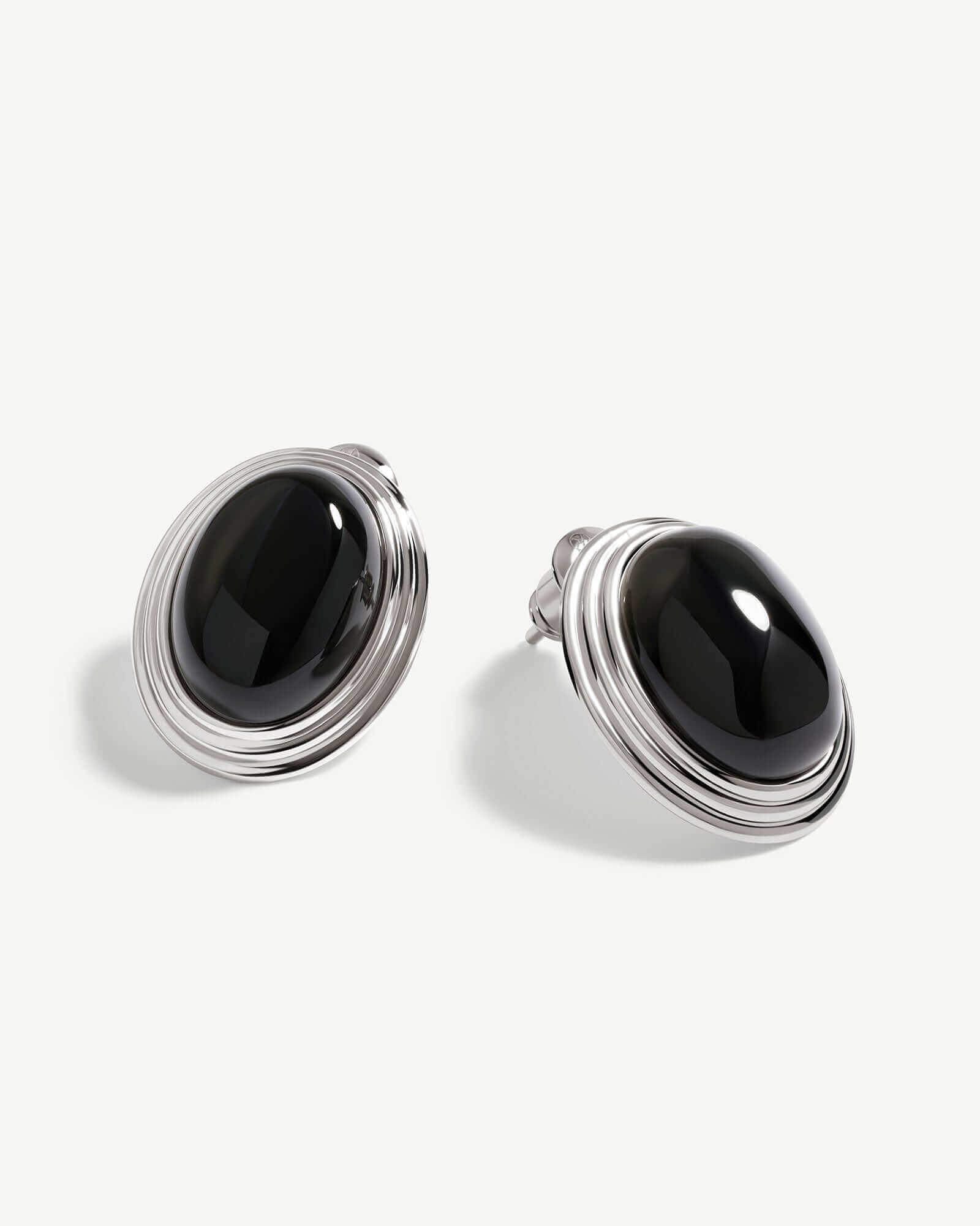 a pair of black stone earrings on a white background