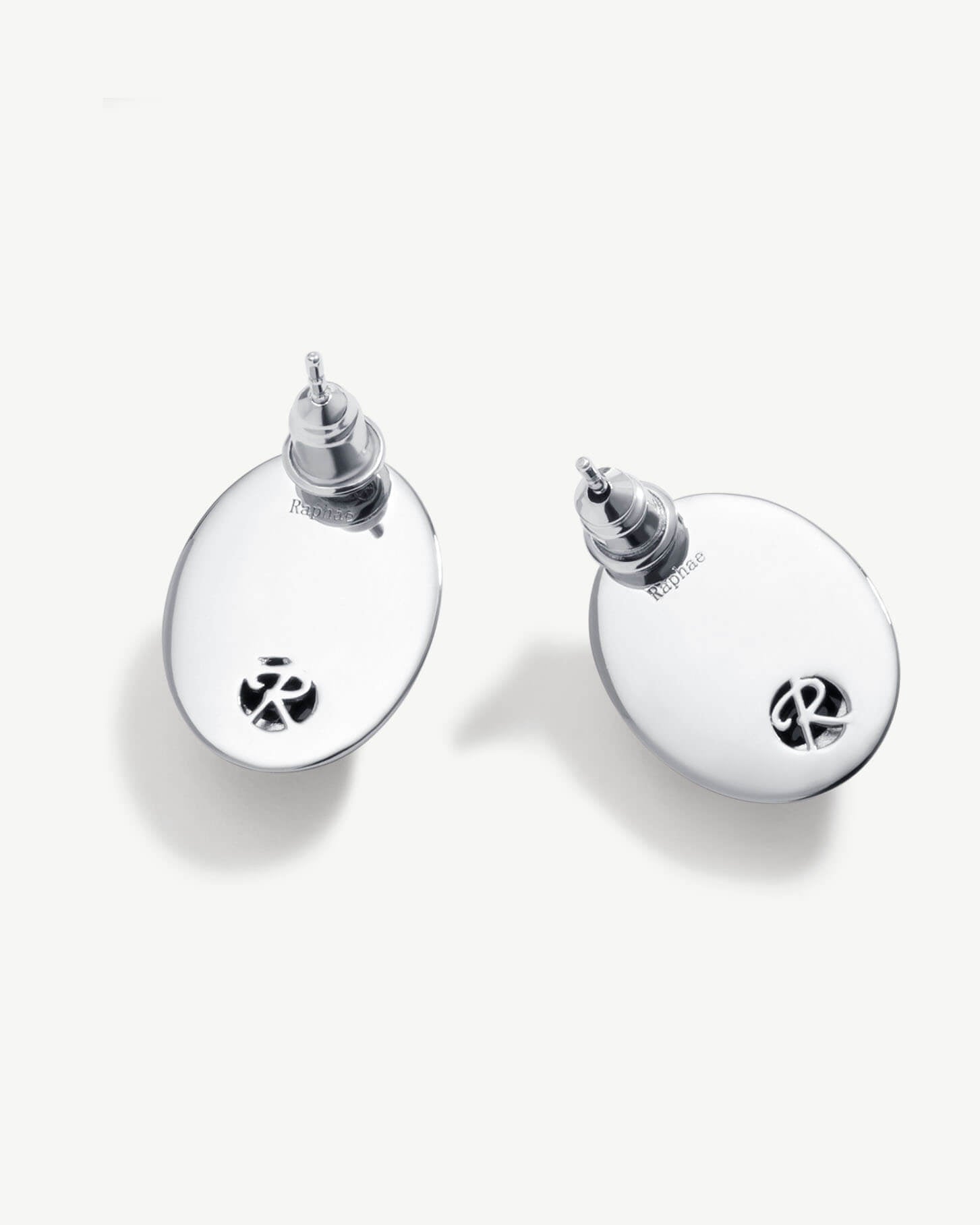 a pair of earrings that are on a white surface