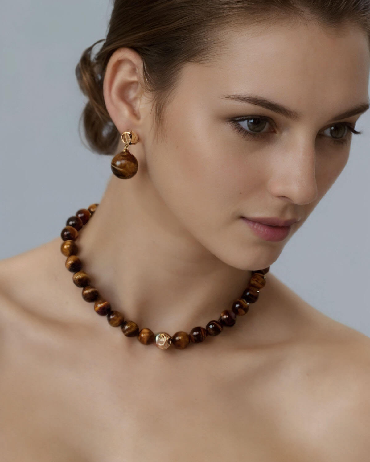 a woman wearing a brown necklace and earrings