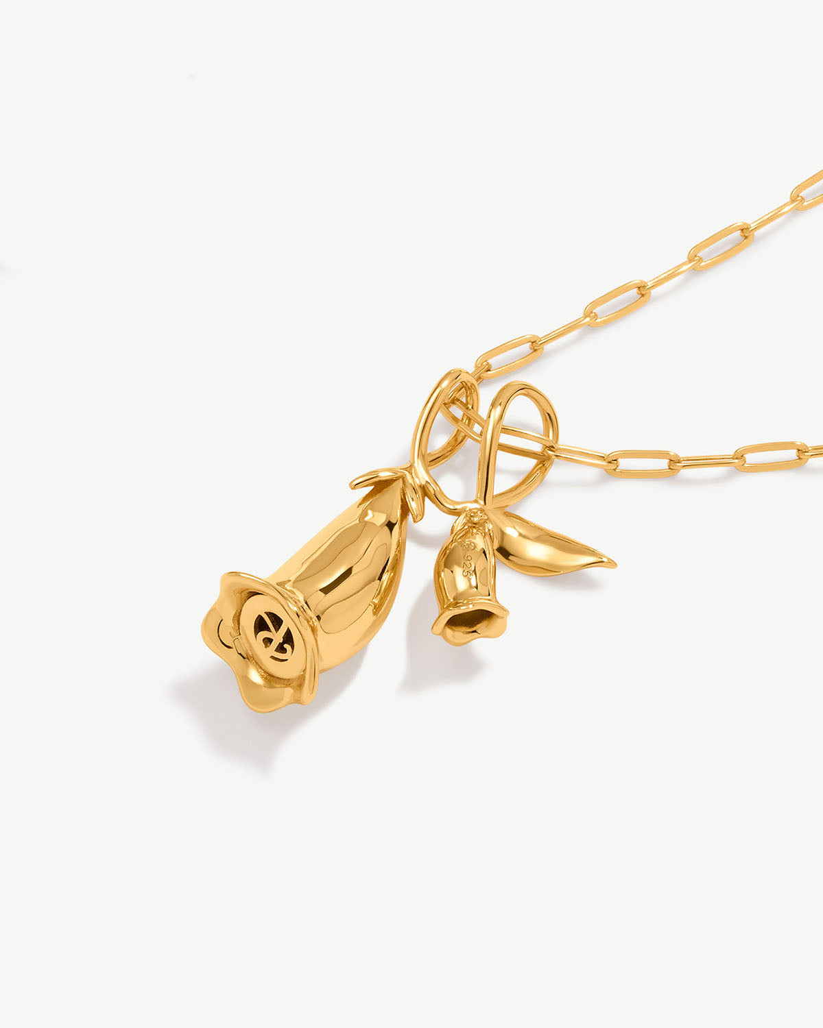 a gold necklace with a bell on a chain