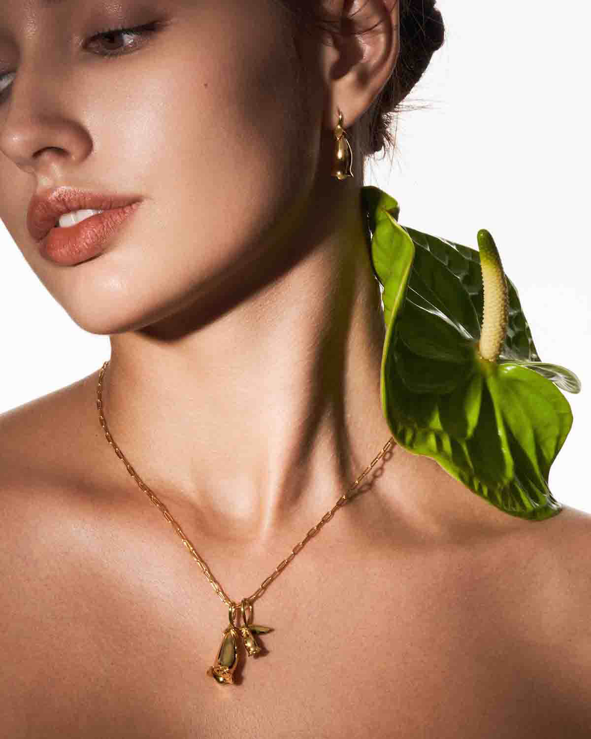 a woman wearing a necklace with a frog on it