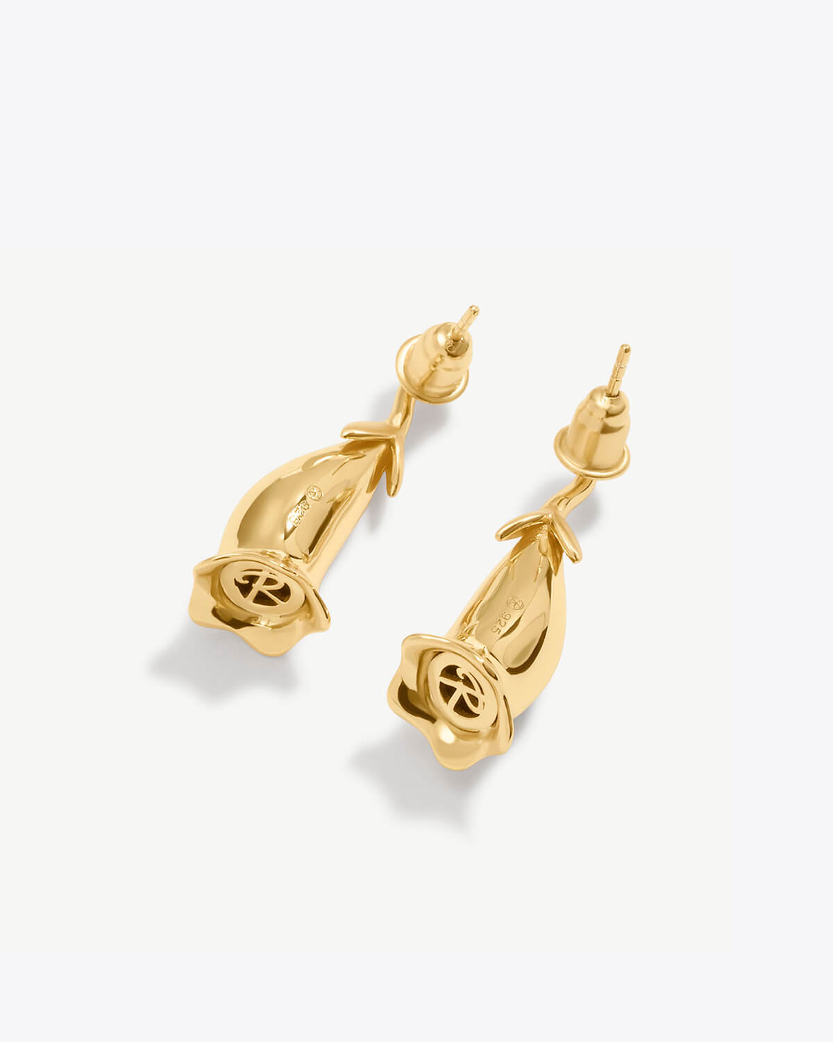 a pair of gold earrings on a white background