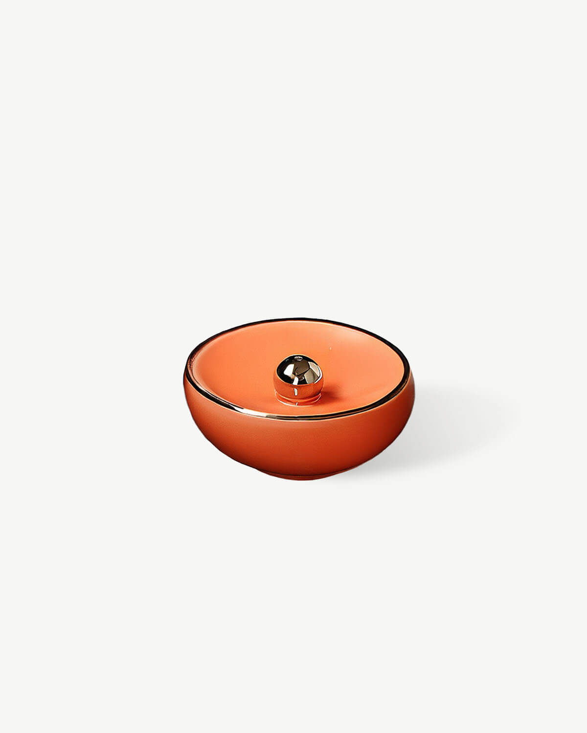 a small orange bowl sitting on top of a white table