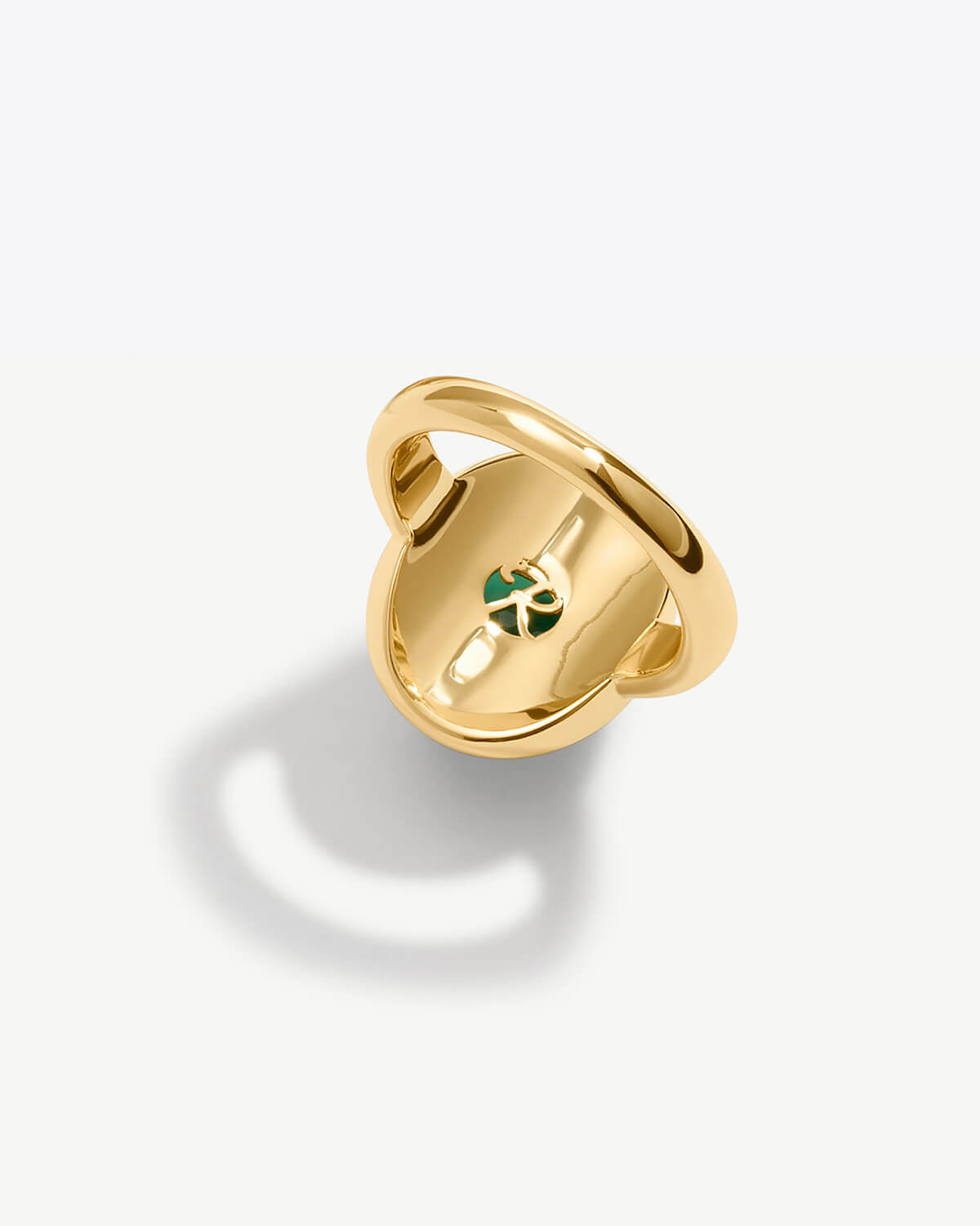 a gold ring with a green logo on it