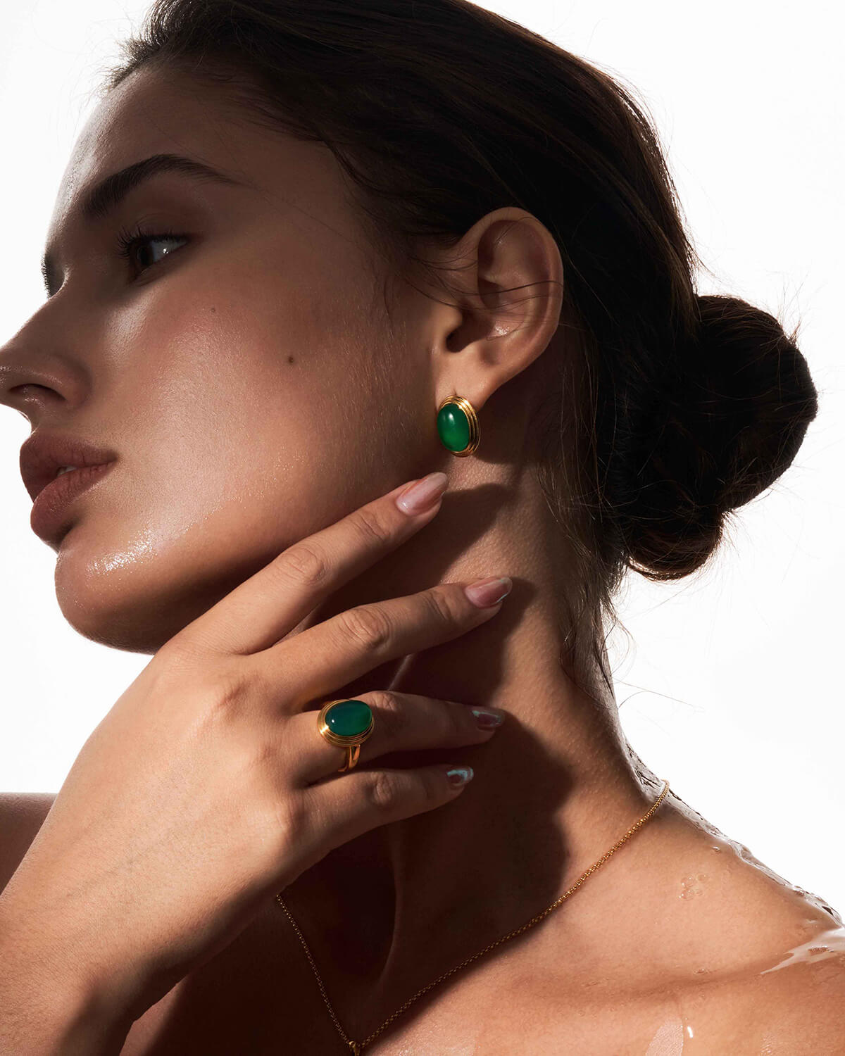 a woman wearing a pair of green earrings