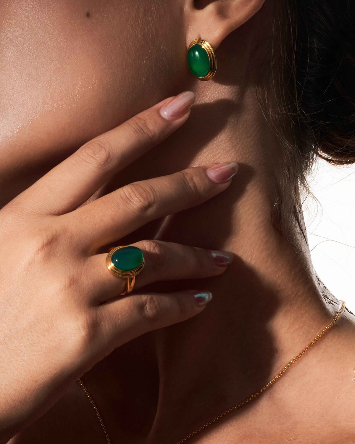 a close up of a person wearing a ring and a necklace