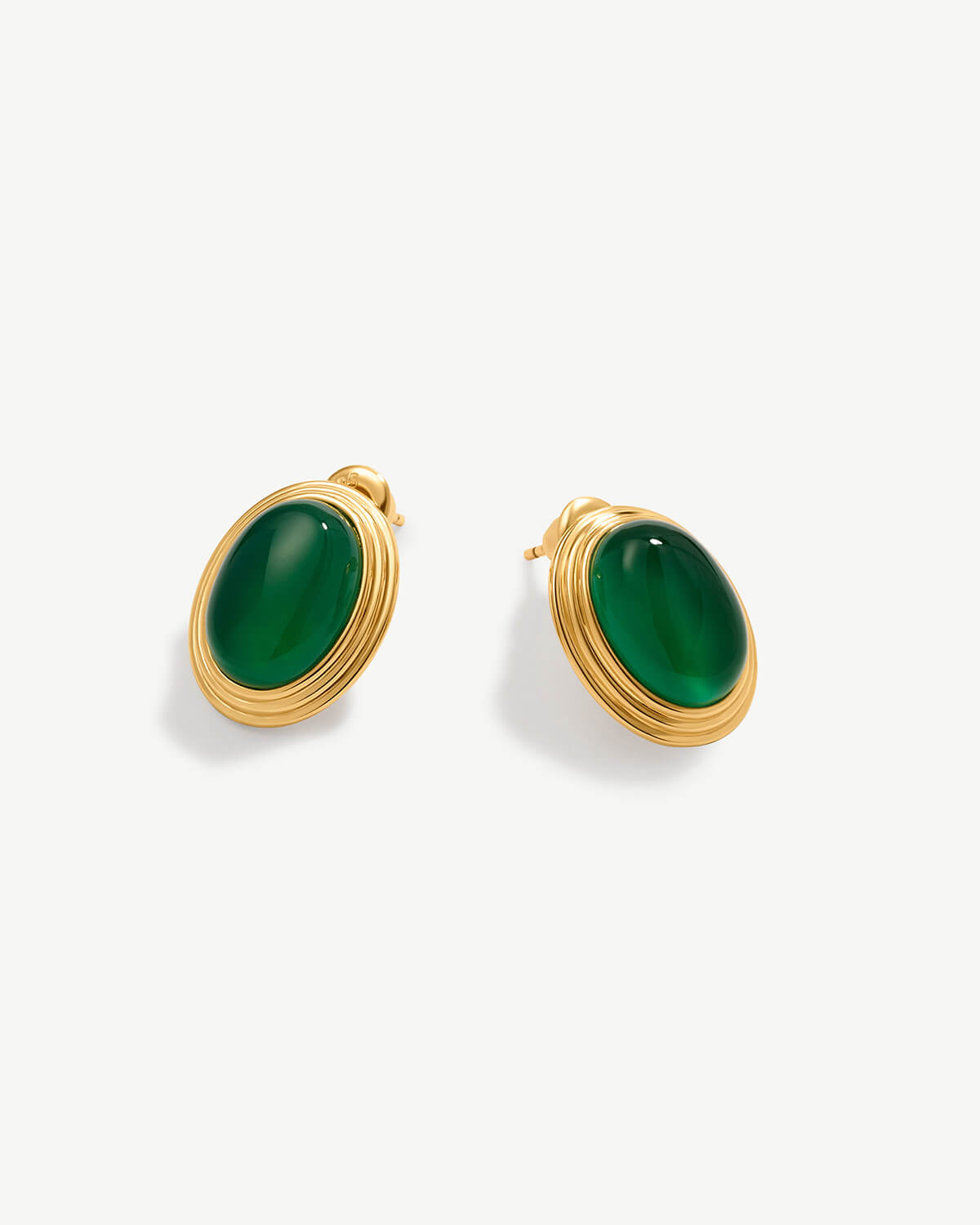 a pair of green stone earrings on a white background