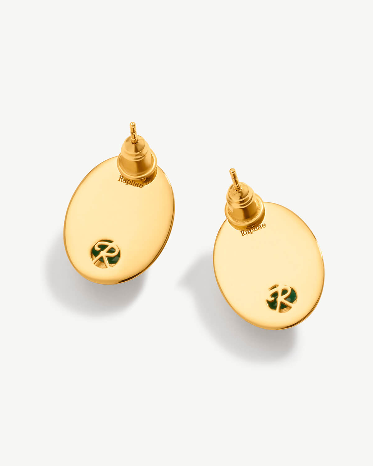 a pair of gold - plated earrings on a white background