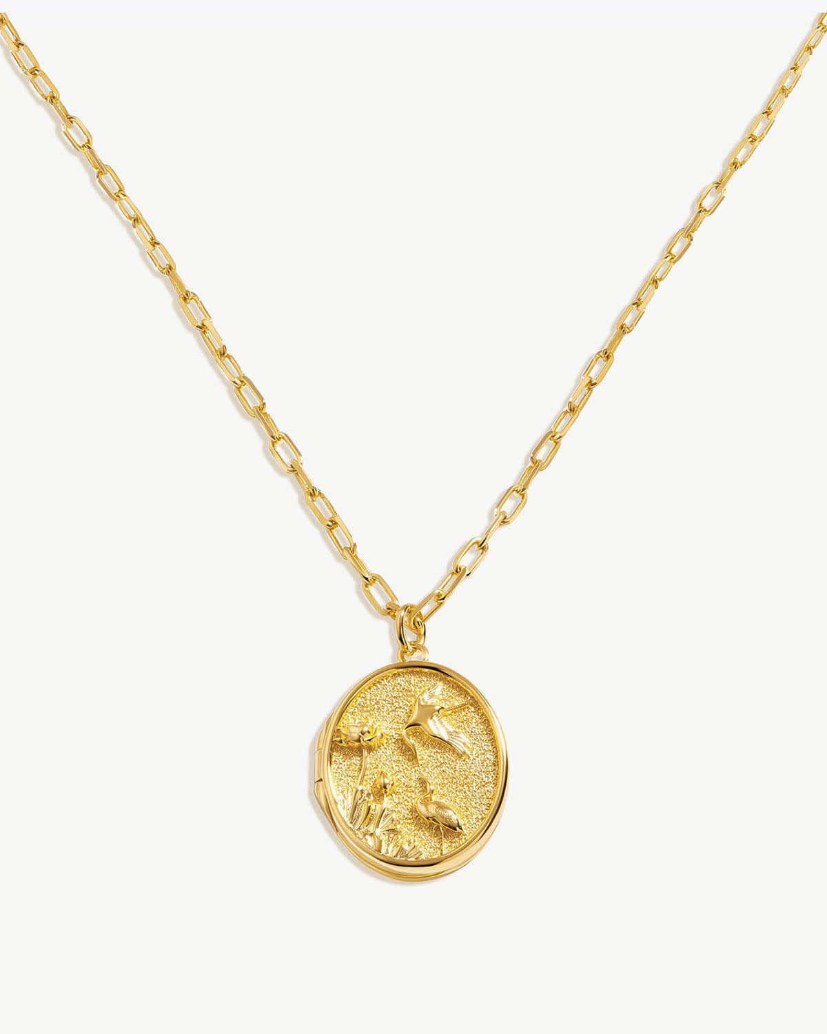 a gold necklace with a coin on a chain