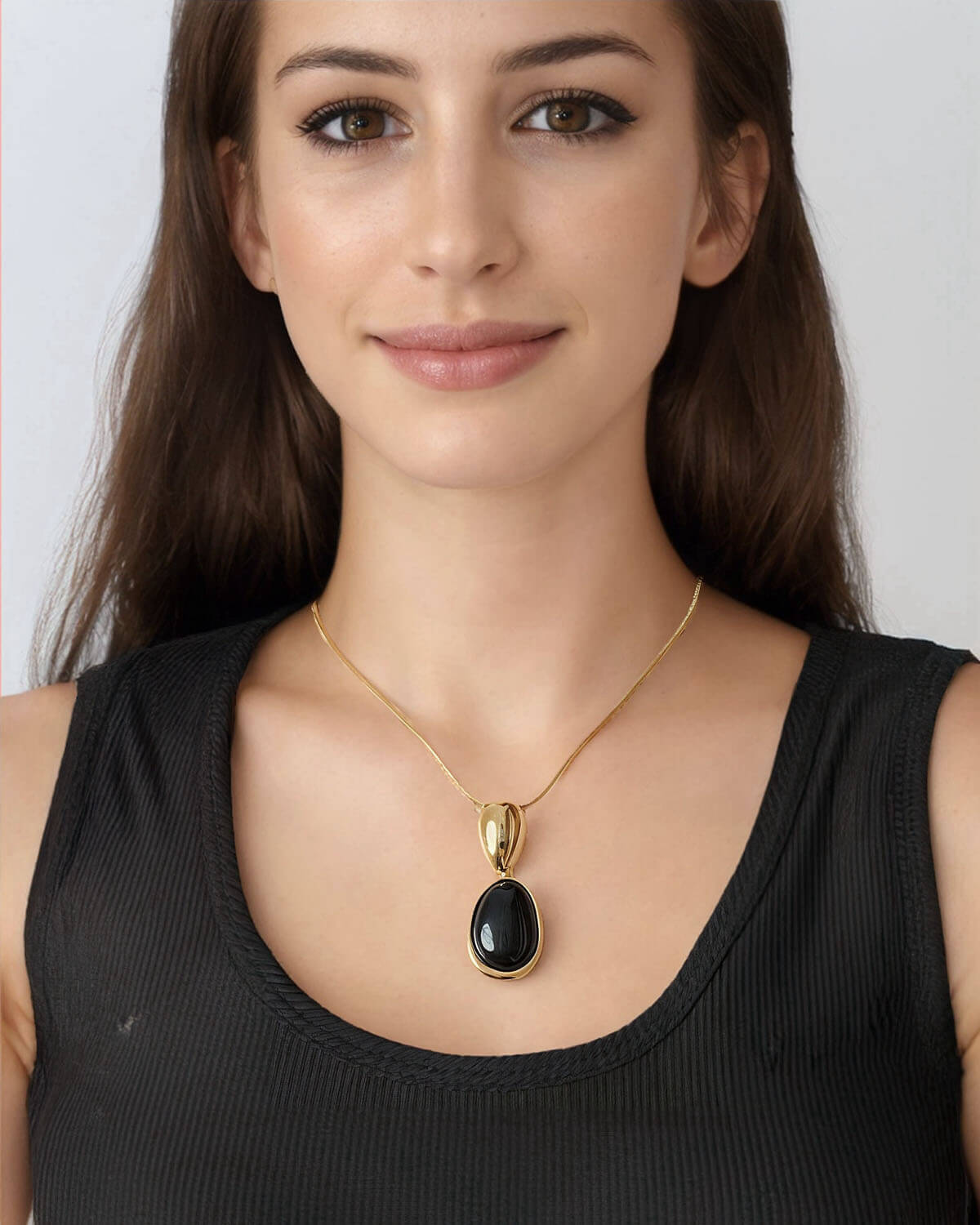 a woman wearing a black top and a gold necklace