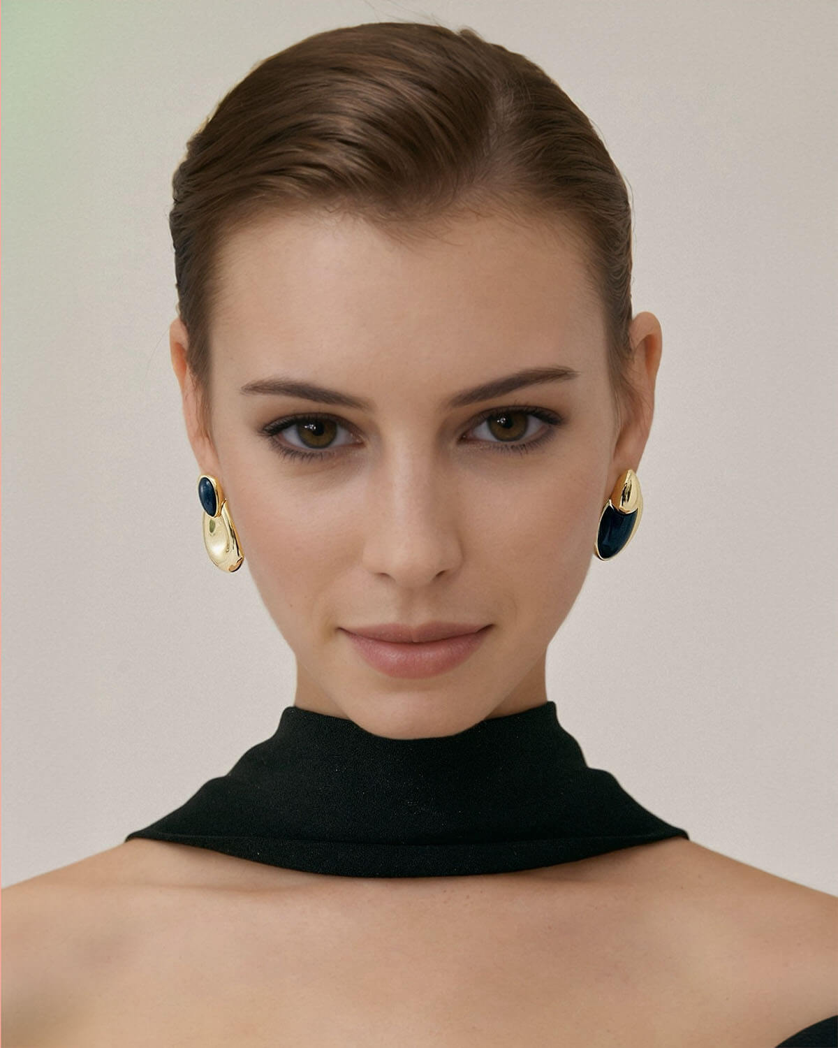 a woman in a black dress with large earrings