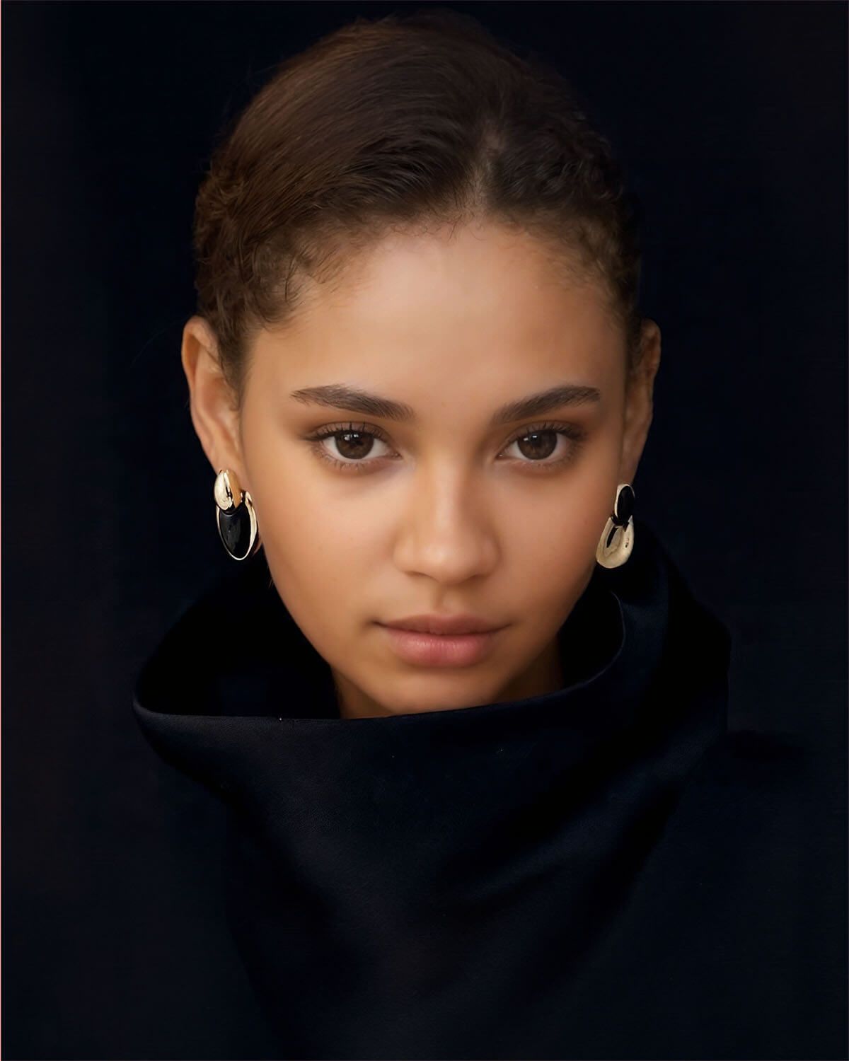 a young woman with large hoop earrings on her head