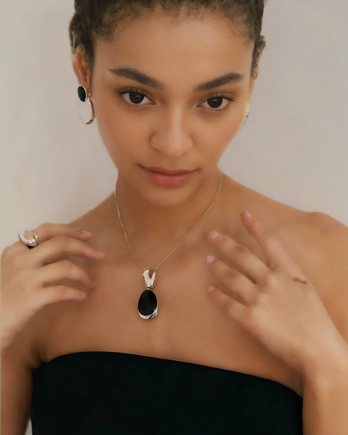 a woman wearing a black strapless dress and a necklace