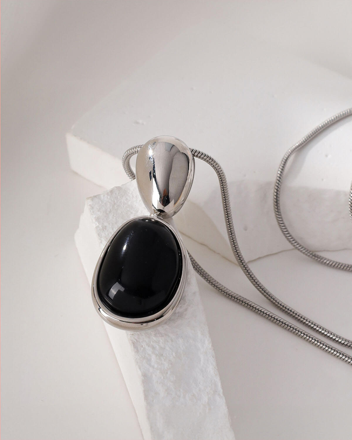 a necklace with a black stone hanging from it