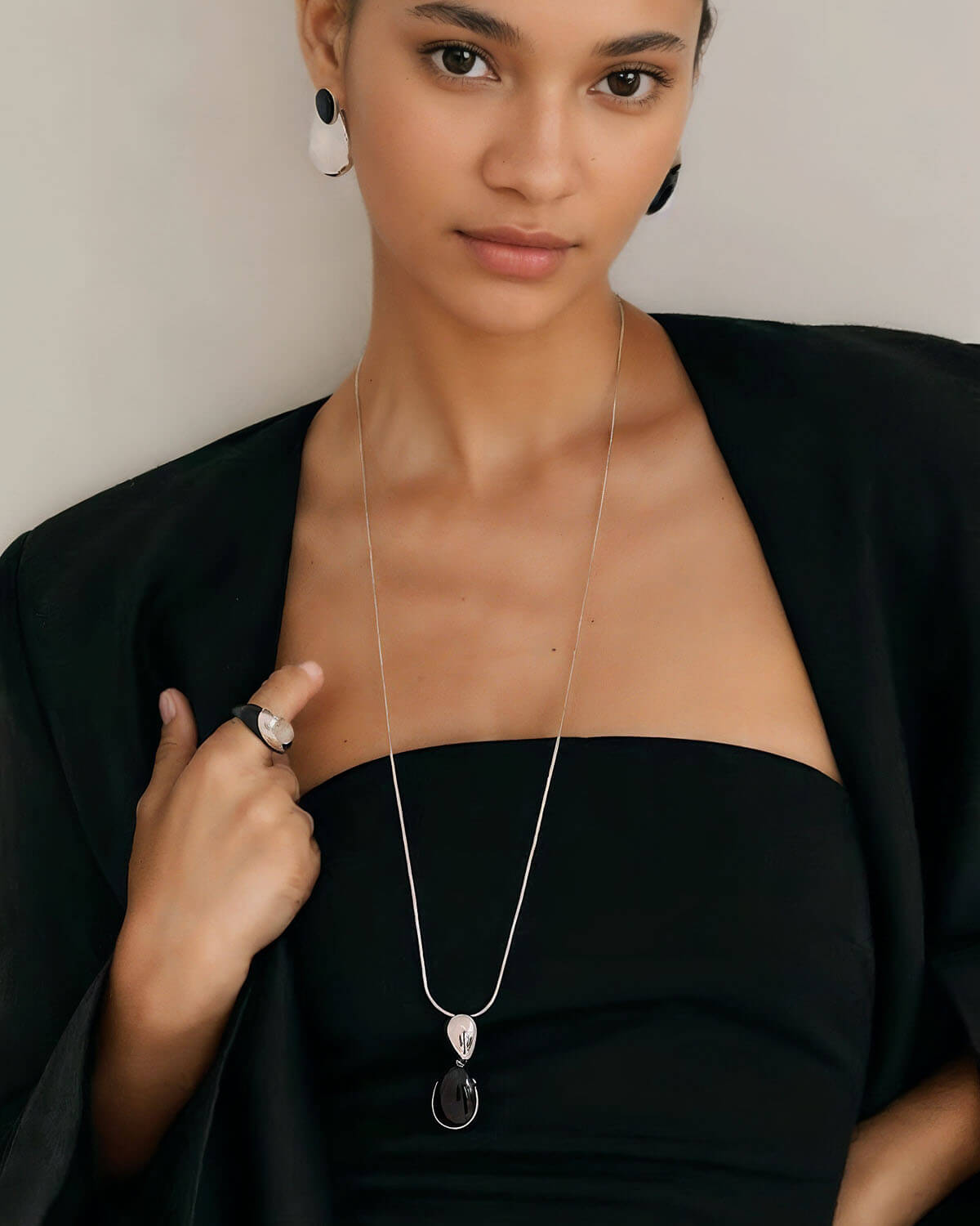 a woman wearing a black dress and a necklace