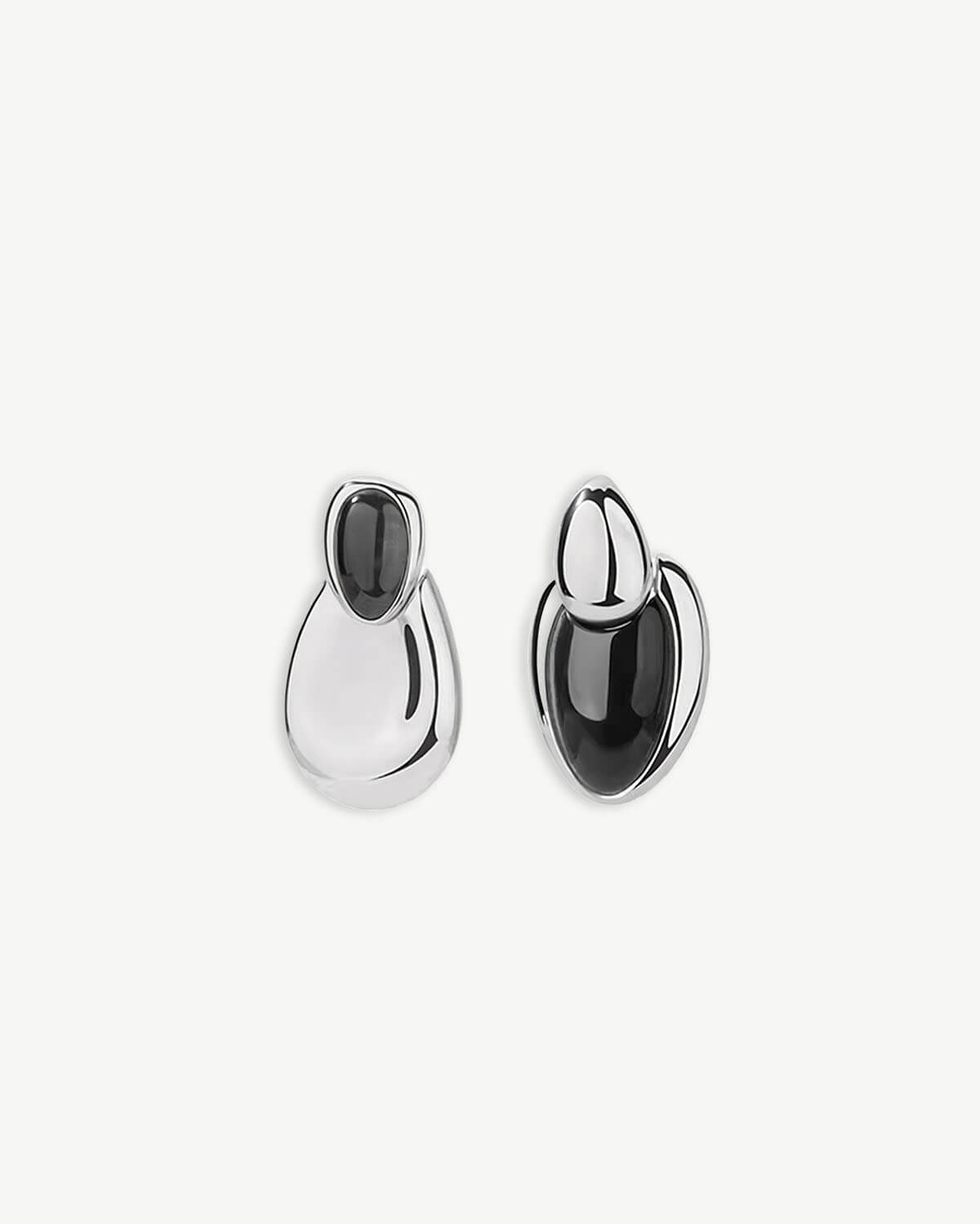 a pair of black and white earrings on a white background