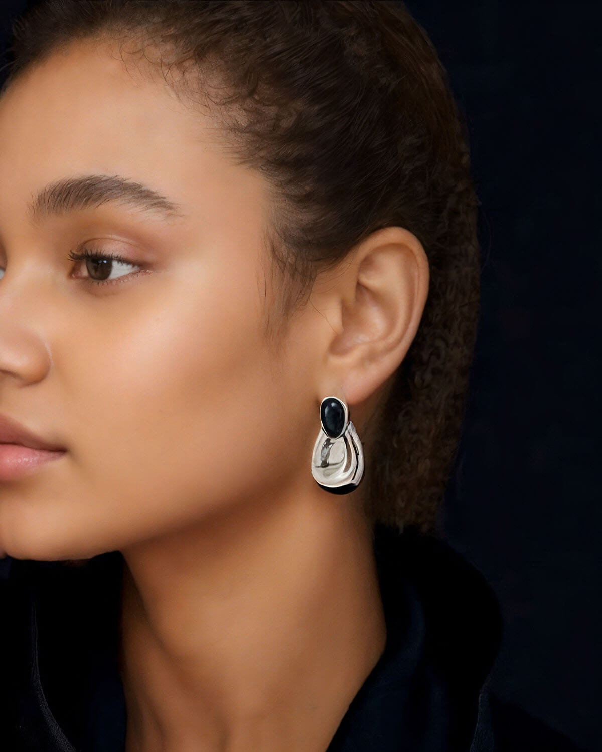 a close up of a person wearing a pair of earrings