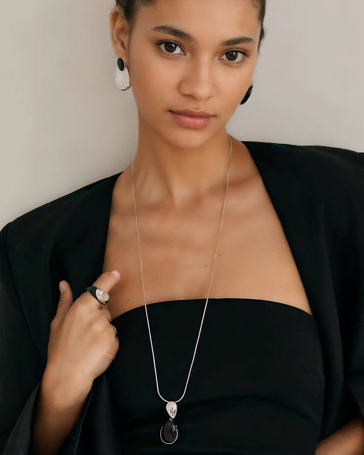 a woman wearing a black top and a necklace