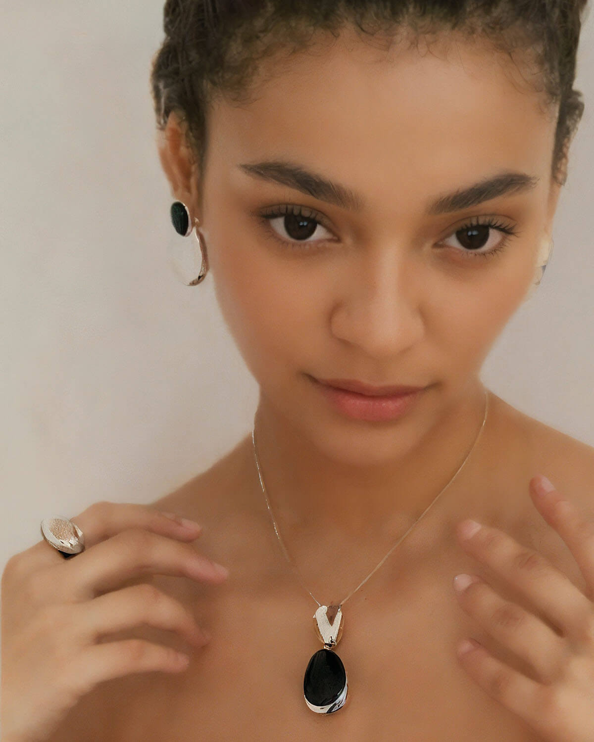 a woman wearing a necklace and earrings