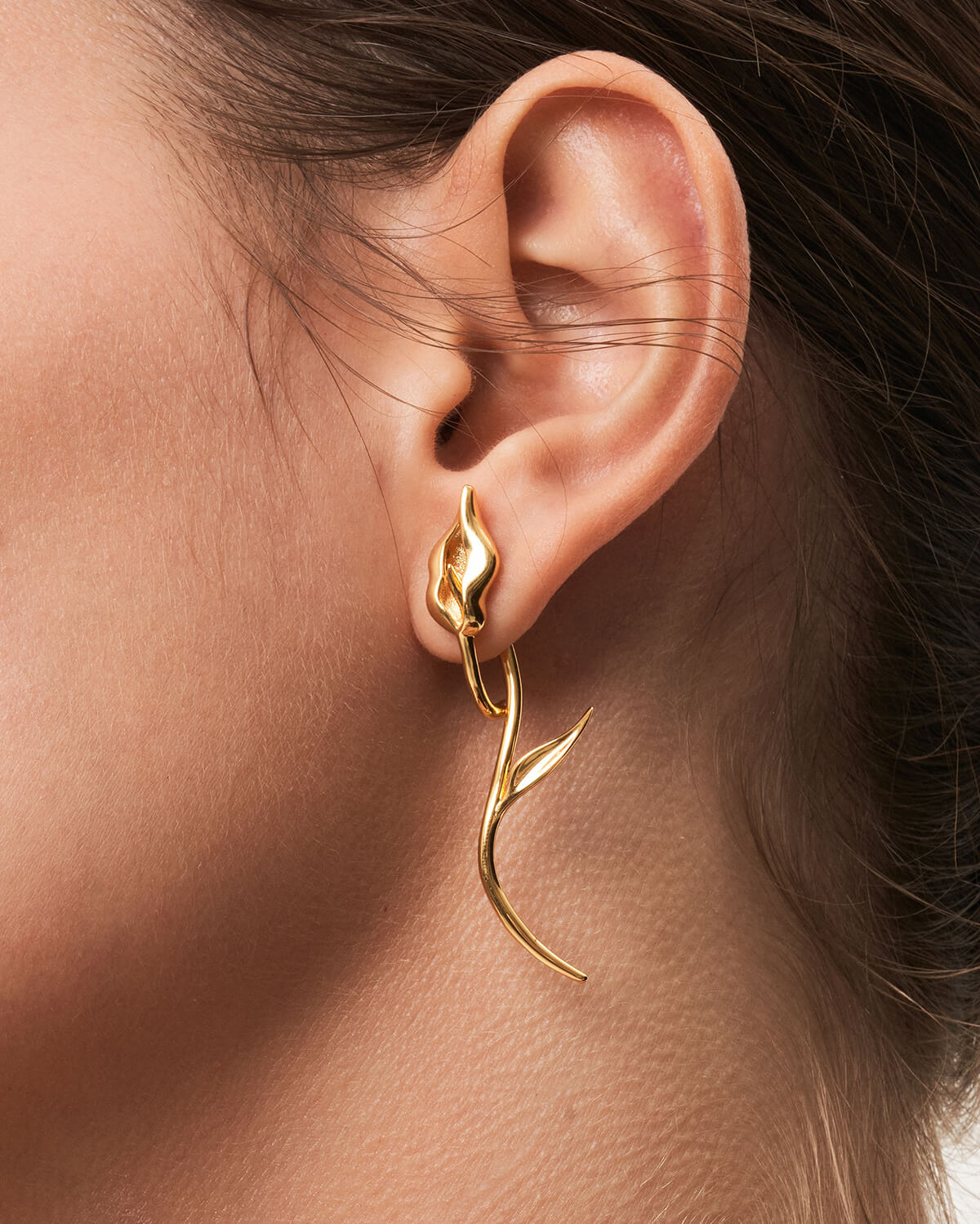 a close up of a person wearing a pair of earrings