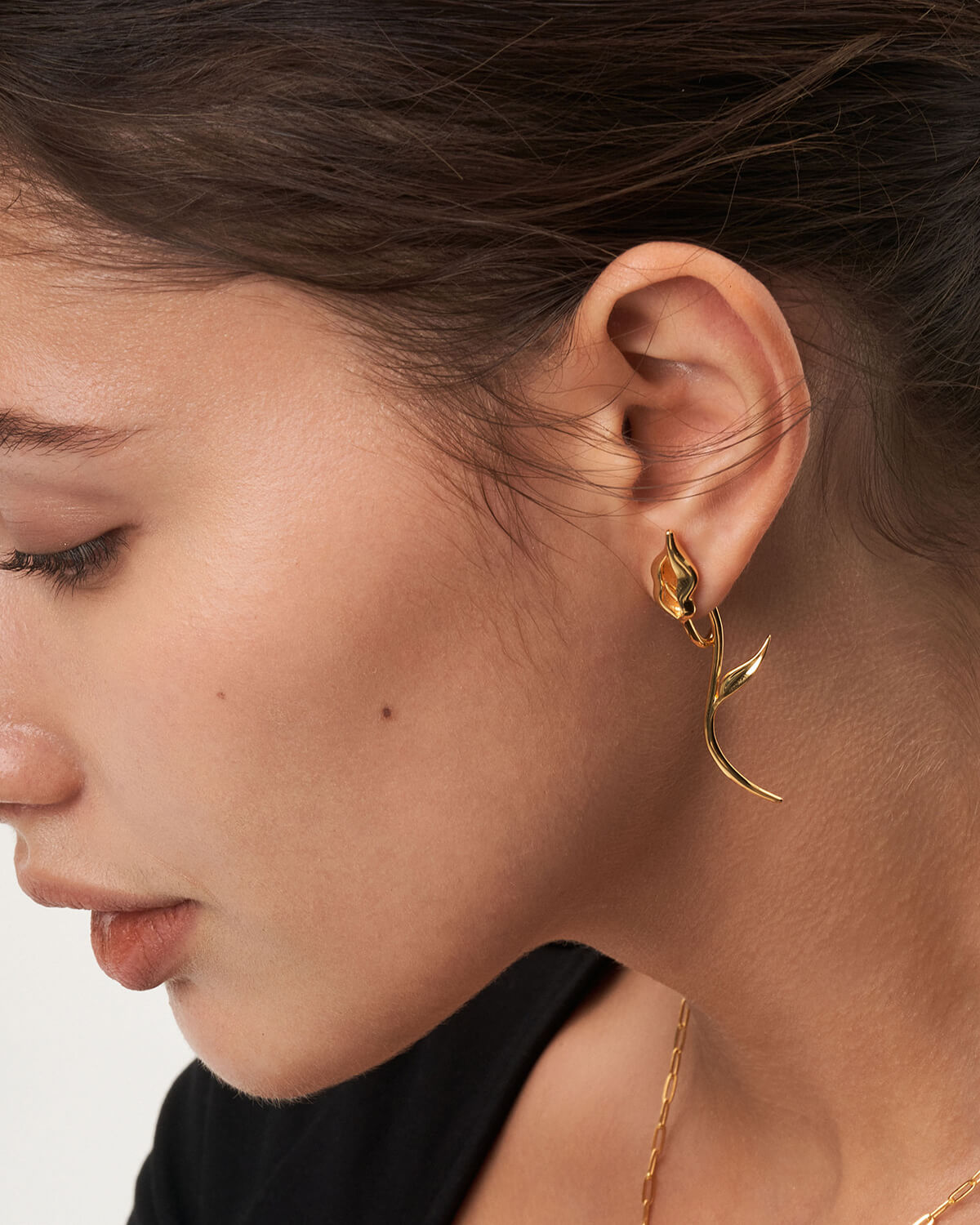 a close up of a person wearing a pair of earrings