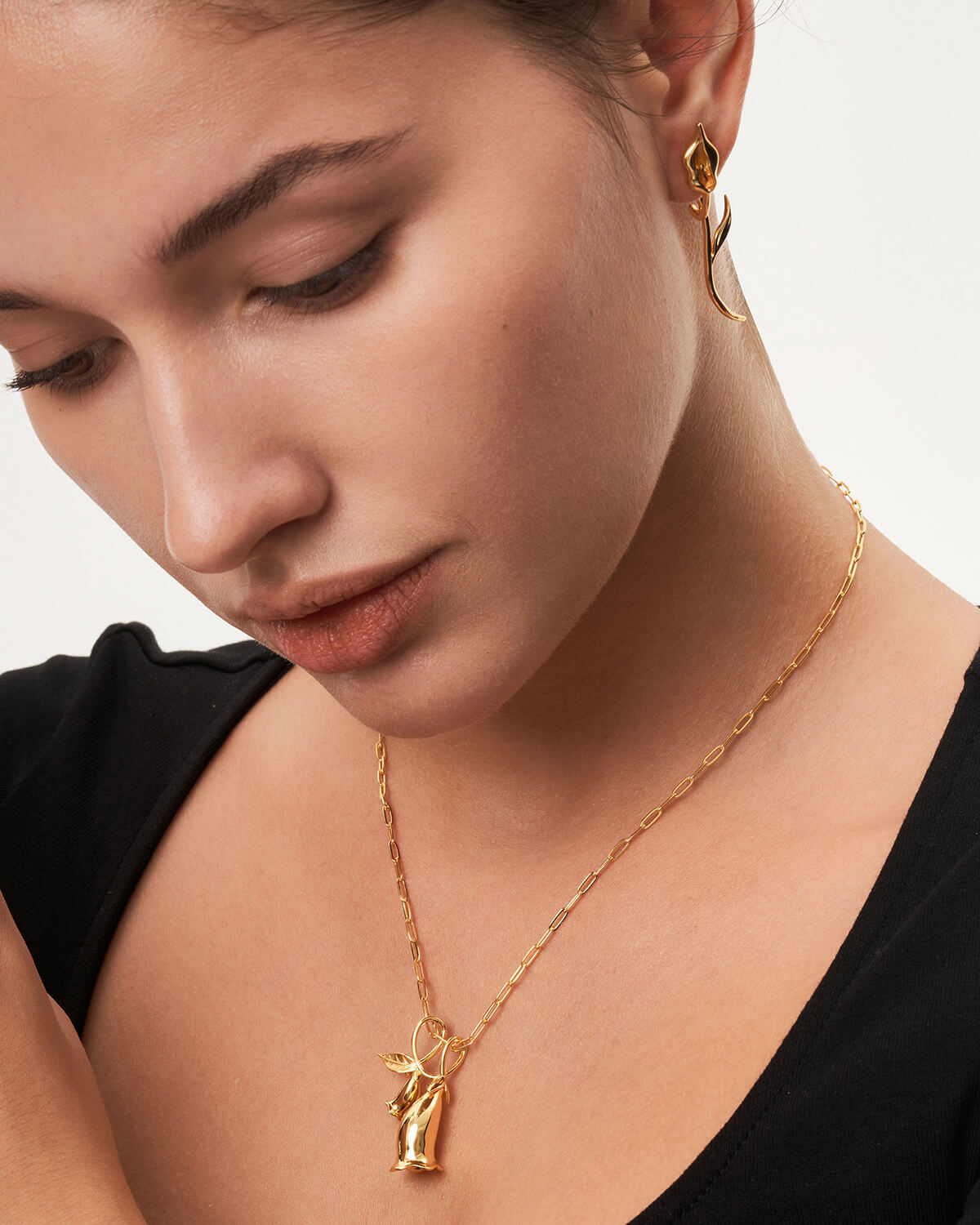 a woman wearing a necklace with a cross on it