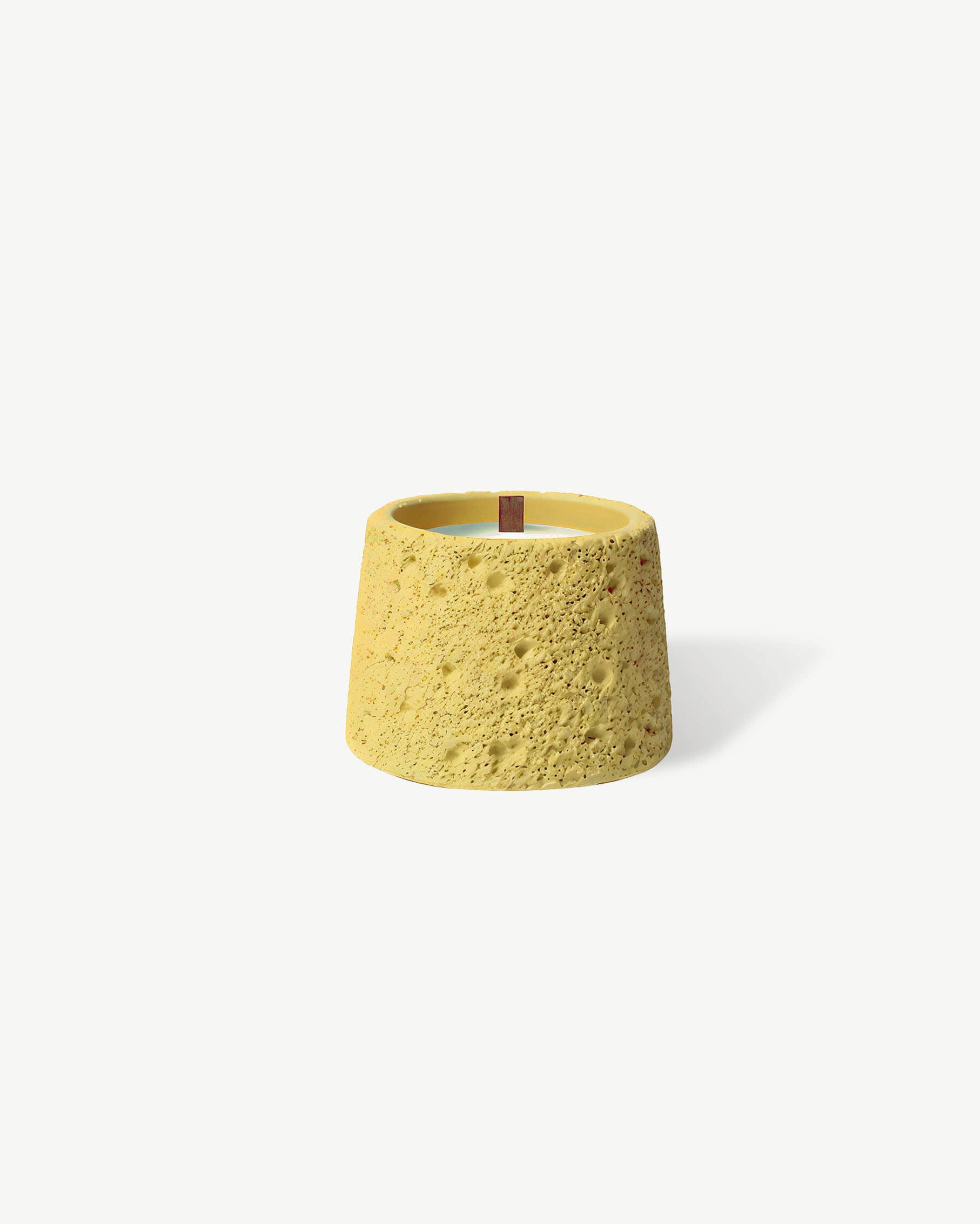 a yellow candle holder on a white background