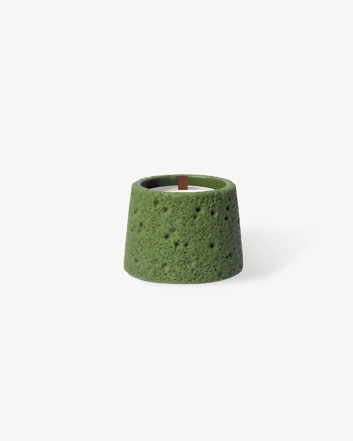 a green candle holder with a wooden stick sticking out of it