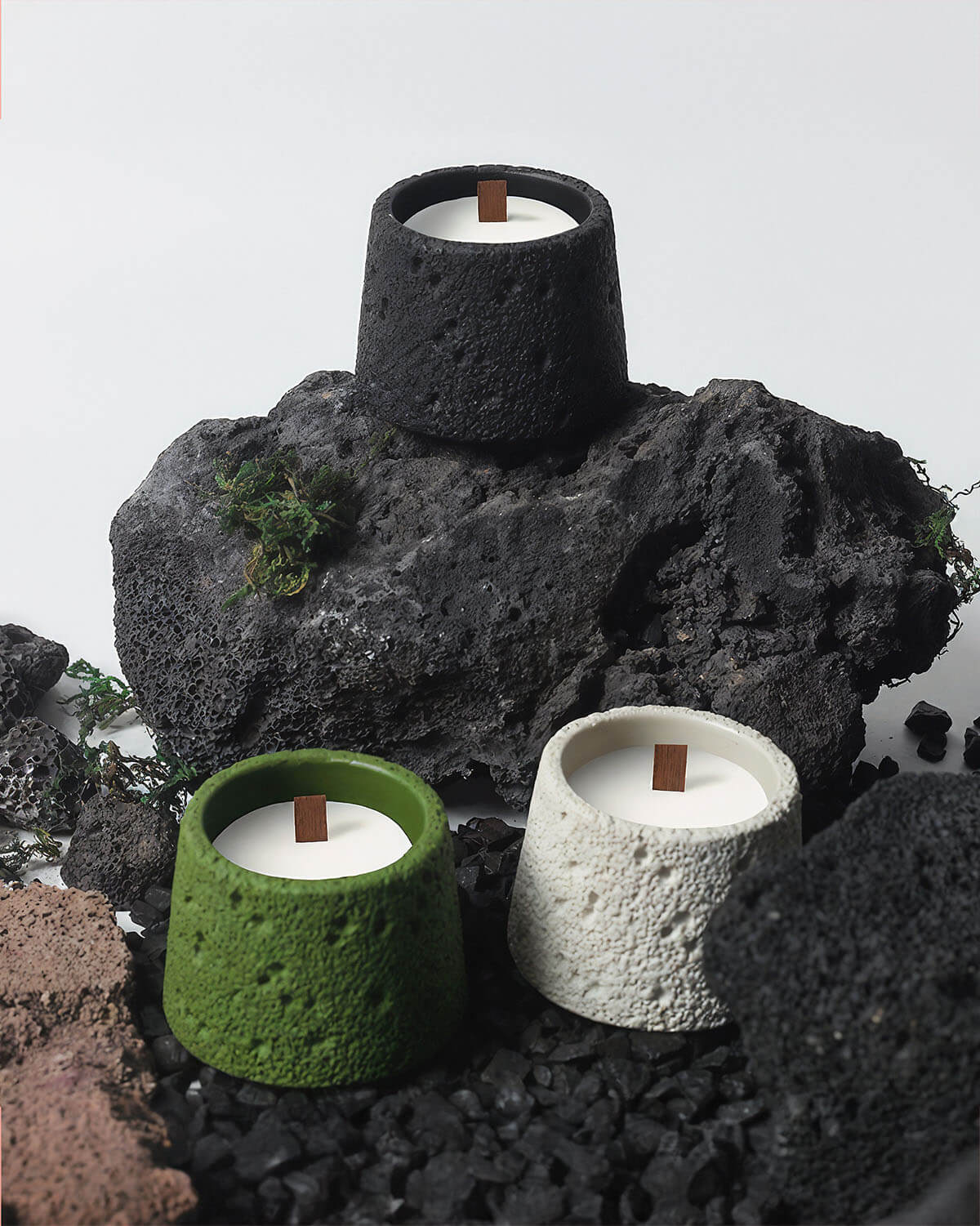 a couple of candles sitting on top of a pile of rocks