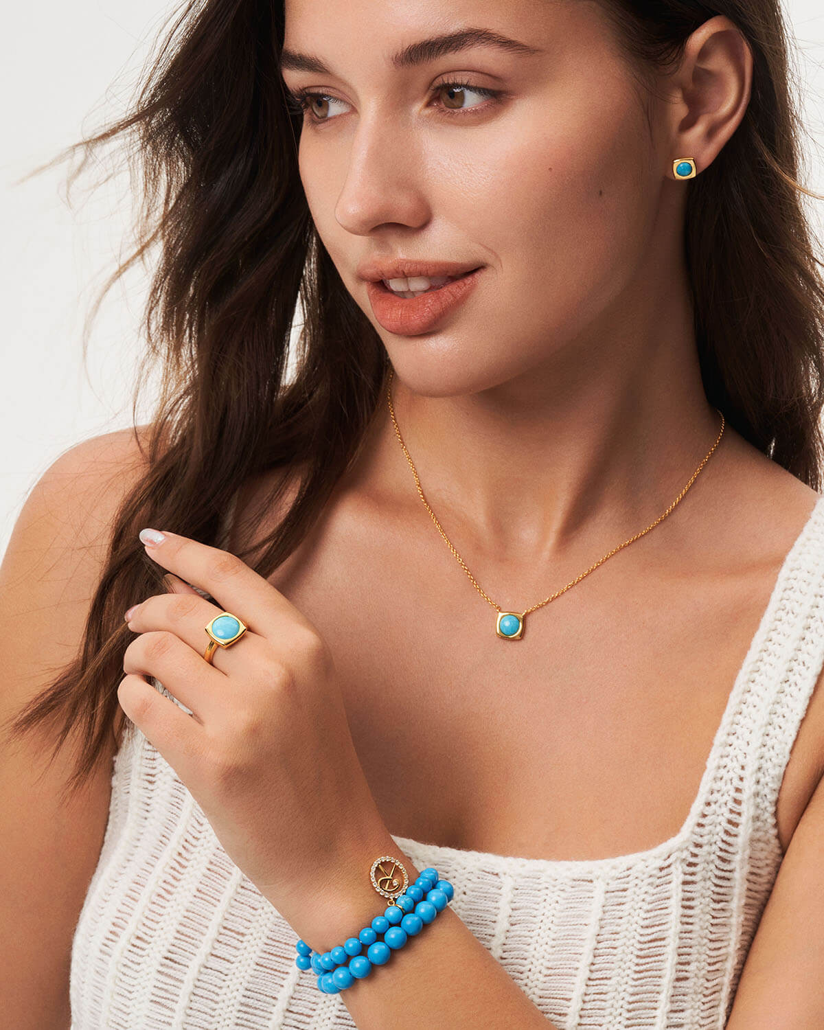 a woman wearing a blue beaded bracelet and a necklace