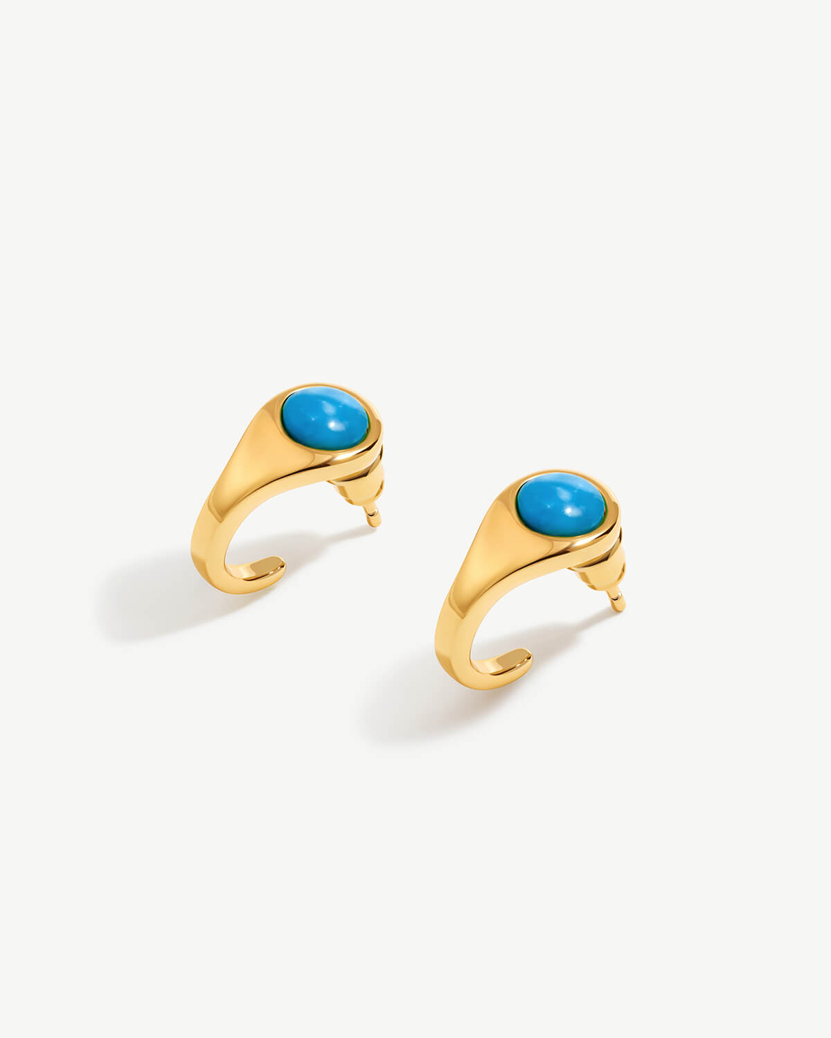 a pair of gold earrings with turquoise stones