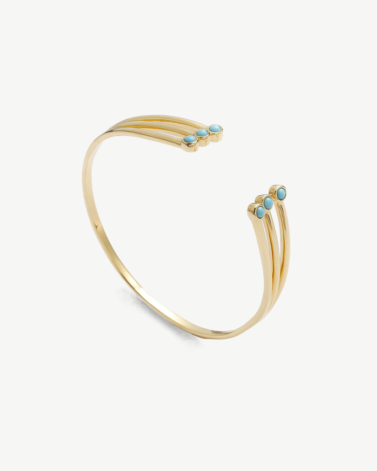 a gold cuff with turquoise stones on it