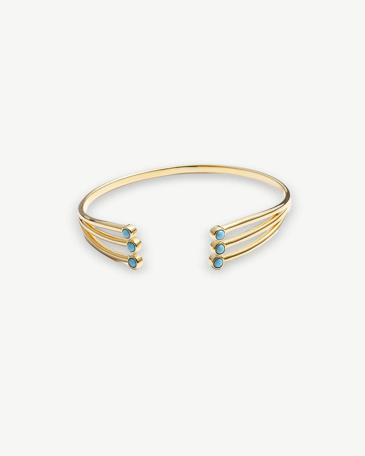 a gold cuff bracelet with turquoise stones