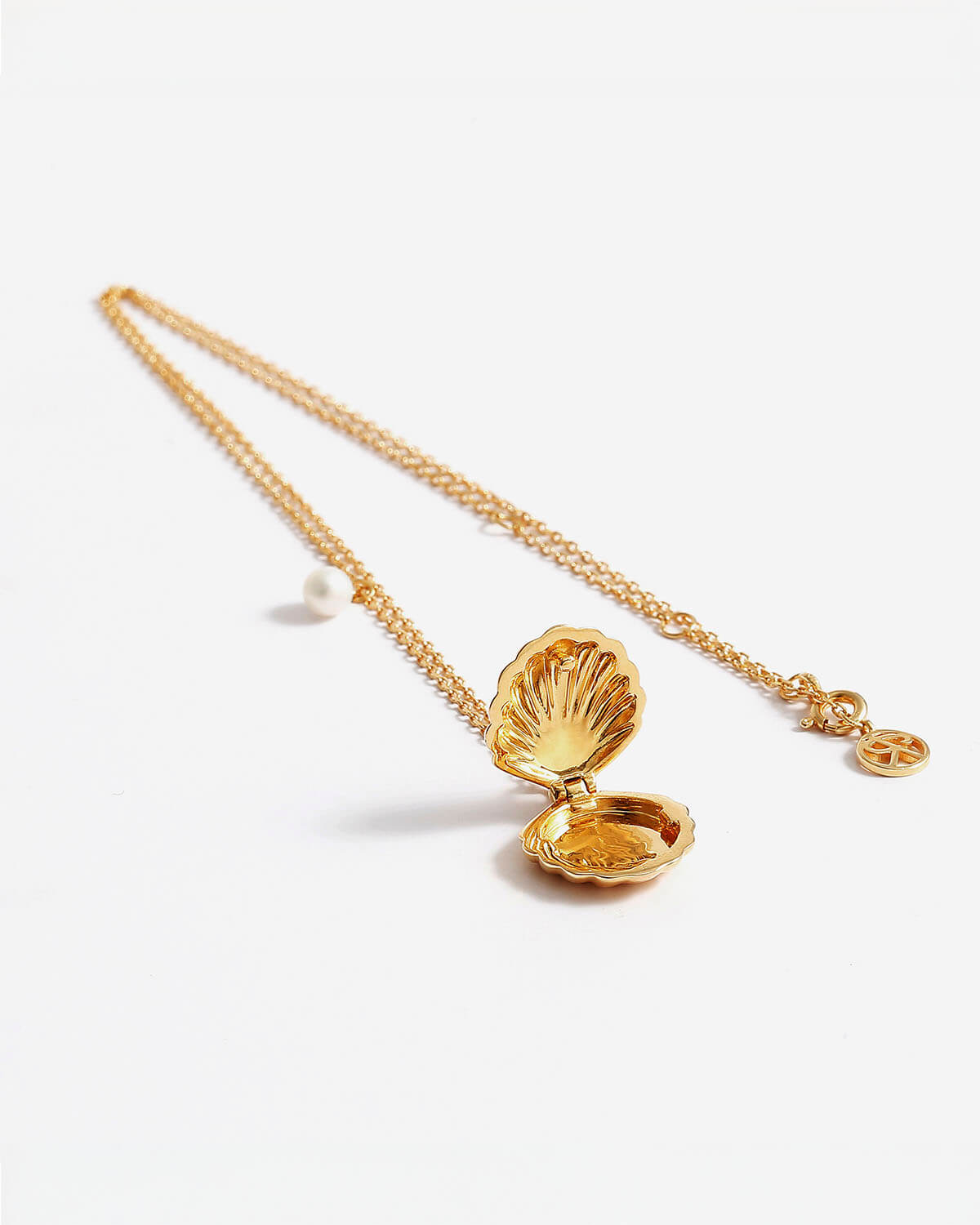 a gold necklace with a shell on it