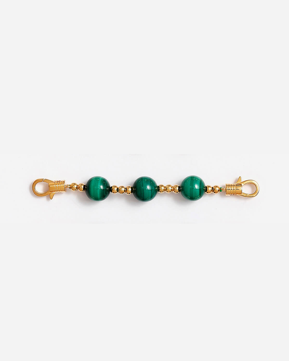 a pair of green beads on a gold chain