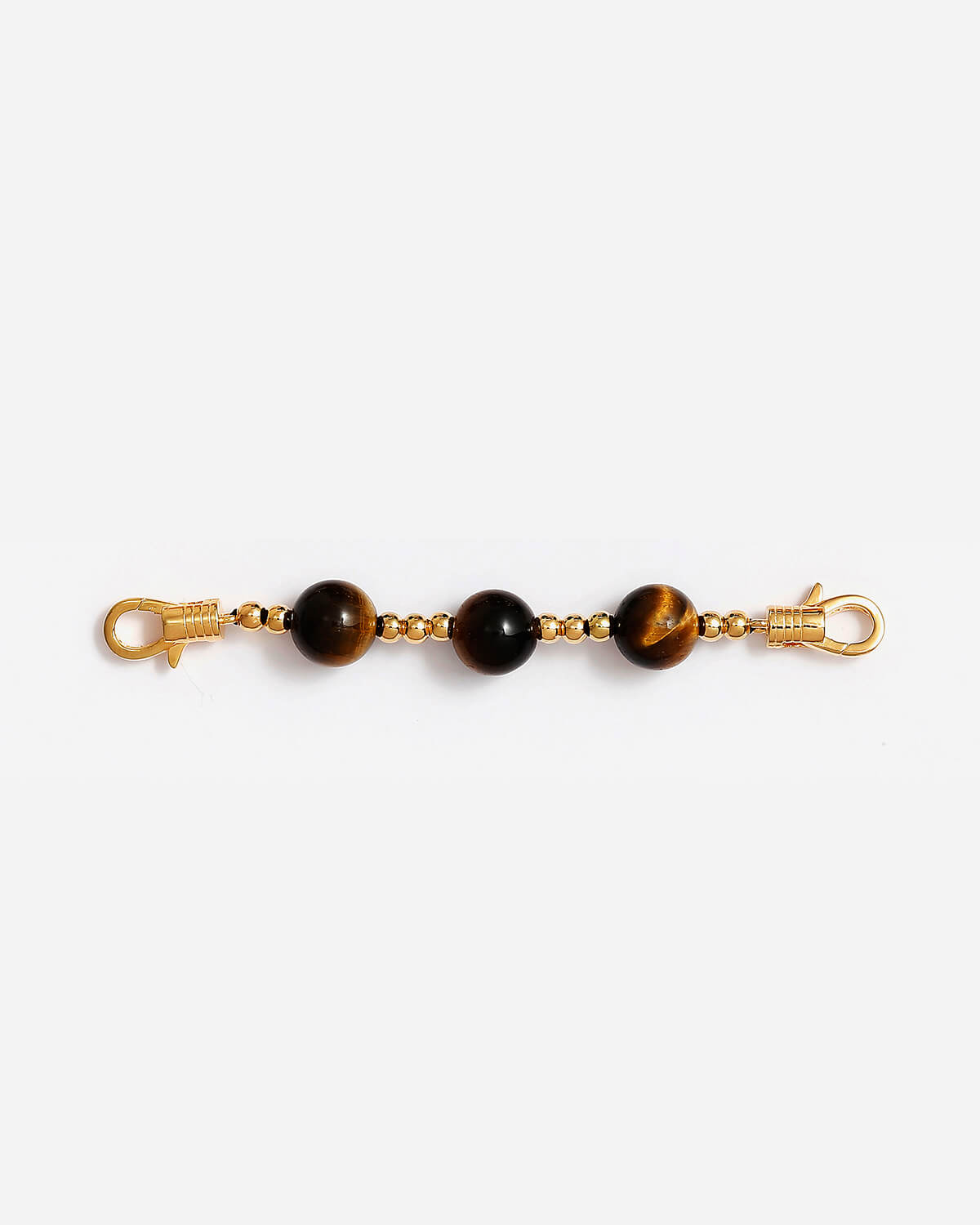 a pair of tiger's eye beads on a gold chain