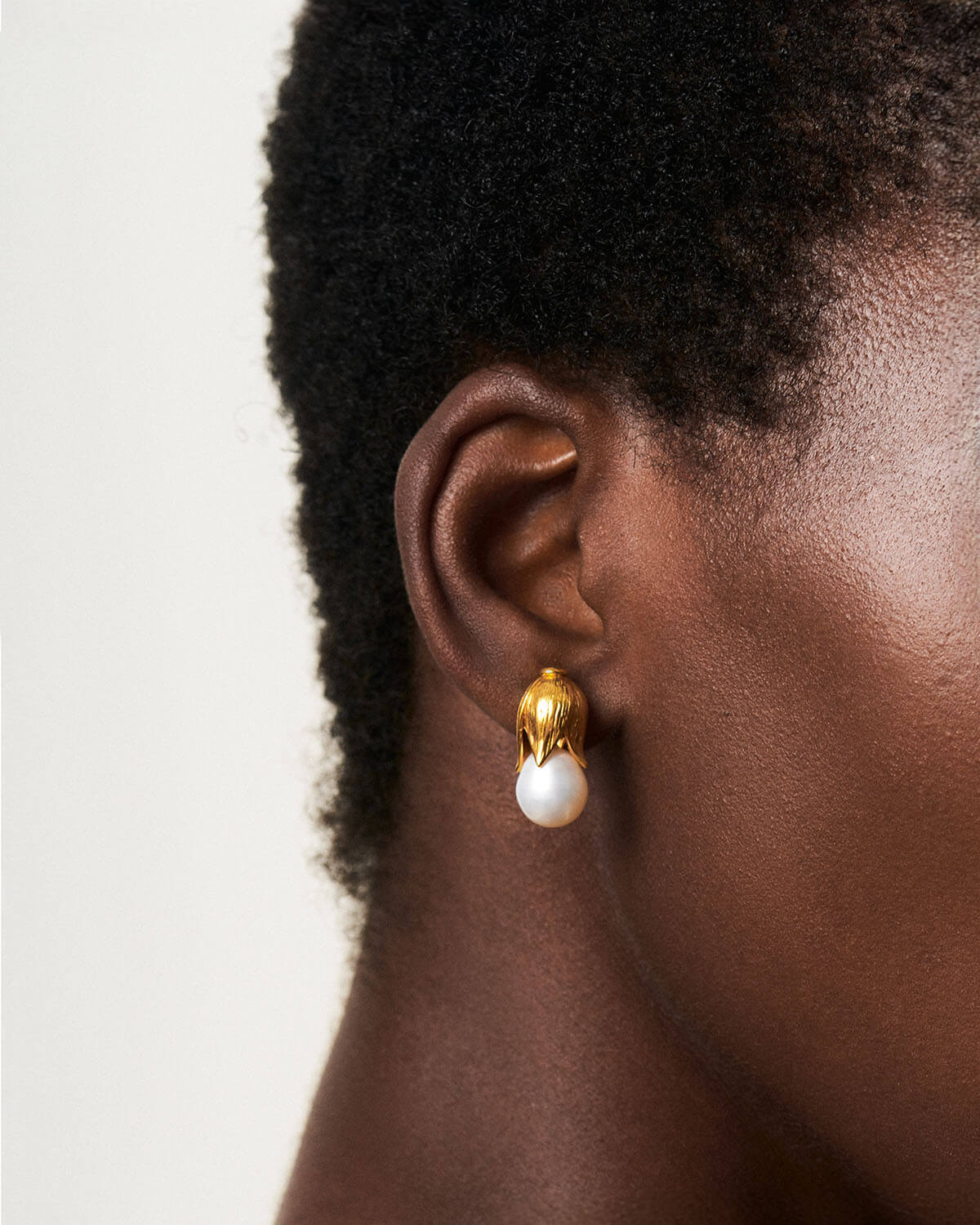 a close up of a person wearing a pair of earrings