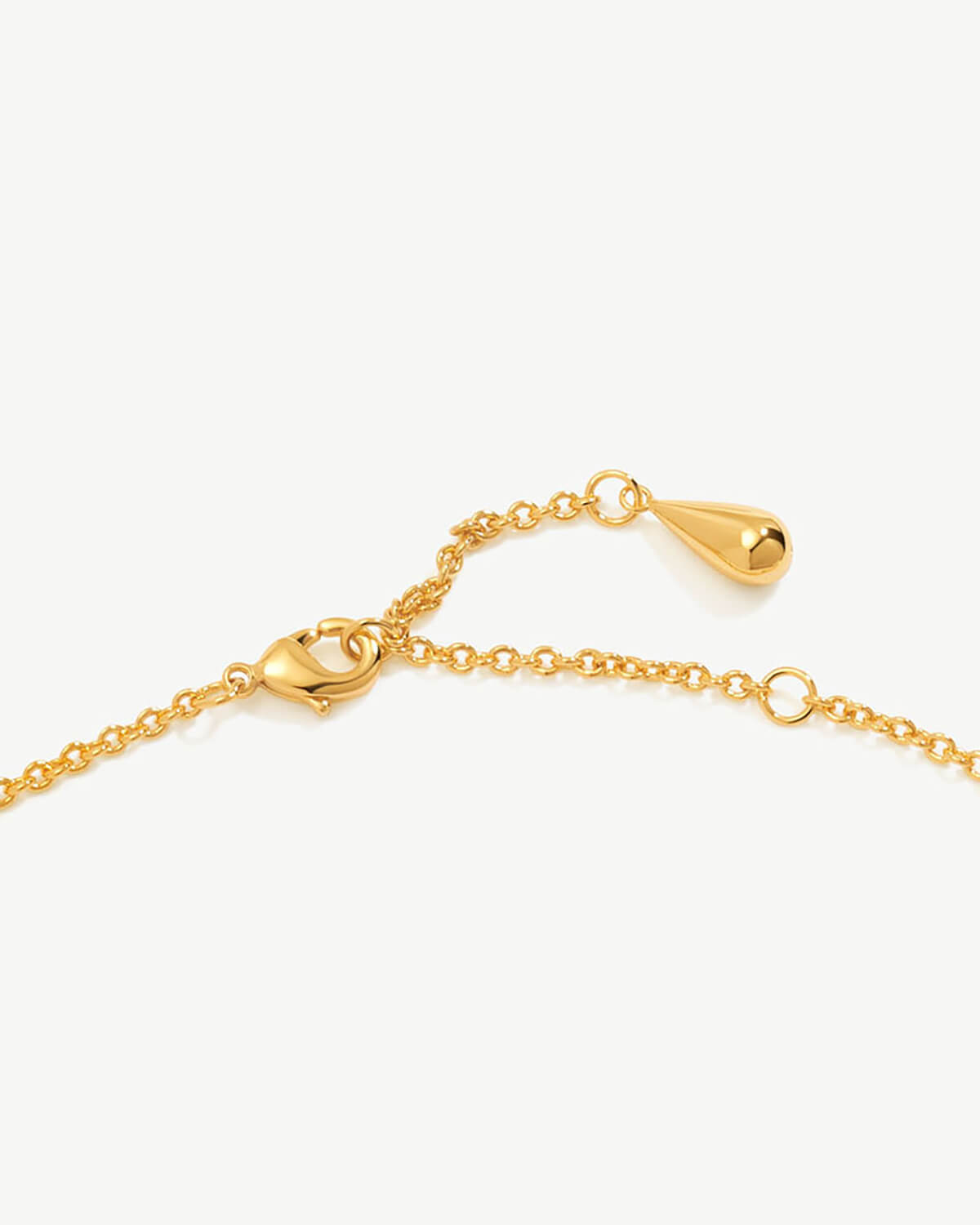 a gold chain bracelet with a heart charm