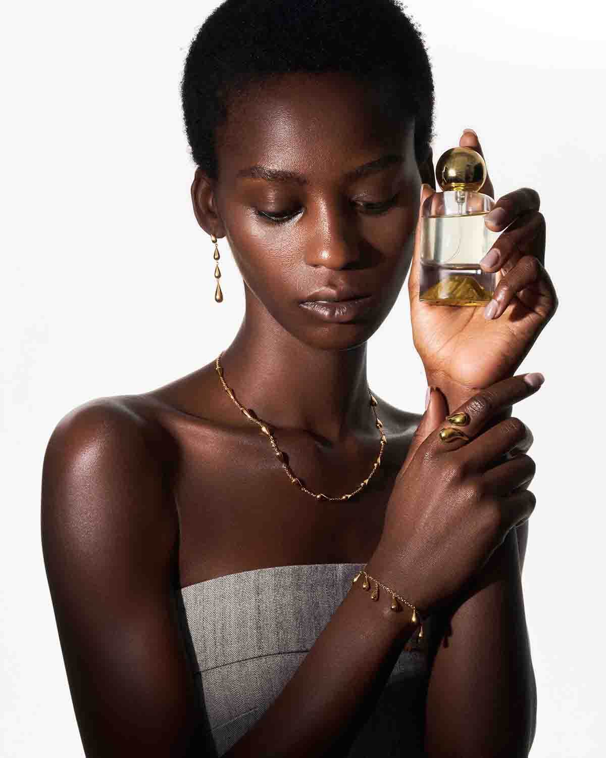 a woman holding a bottle of perfume in her hands