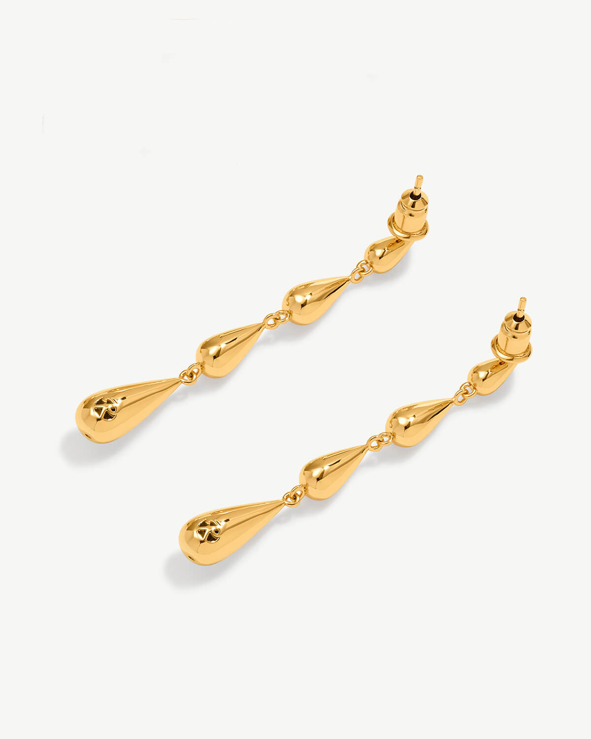 a pair of gold earrings on a white background