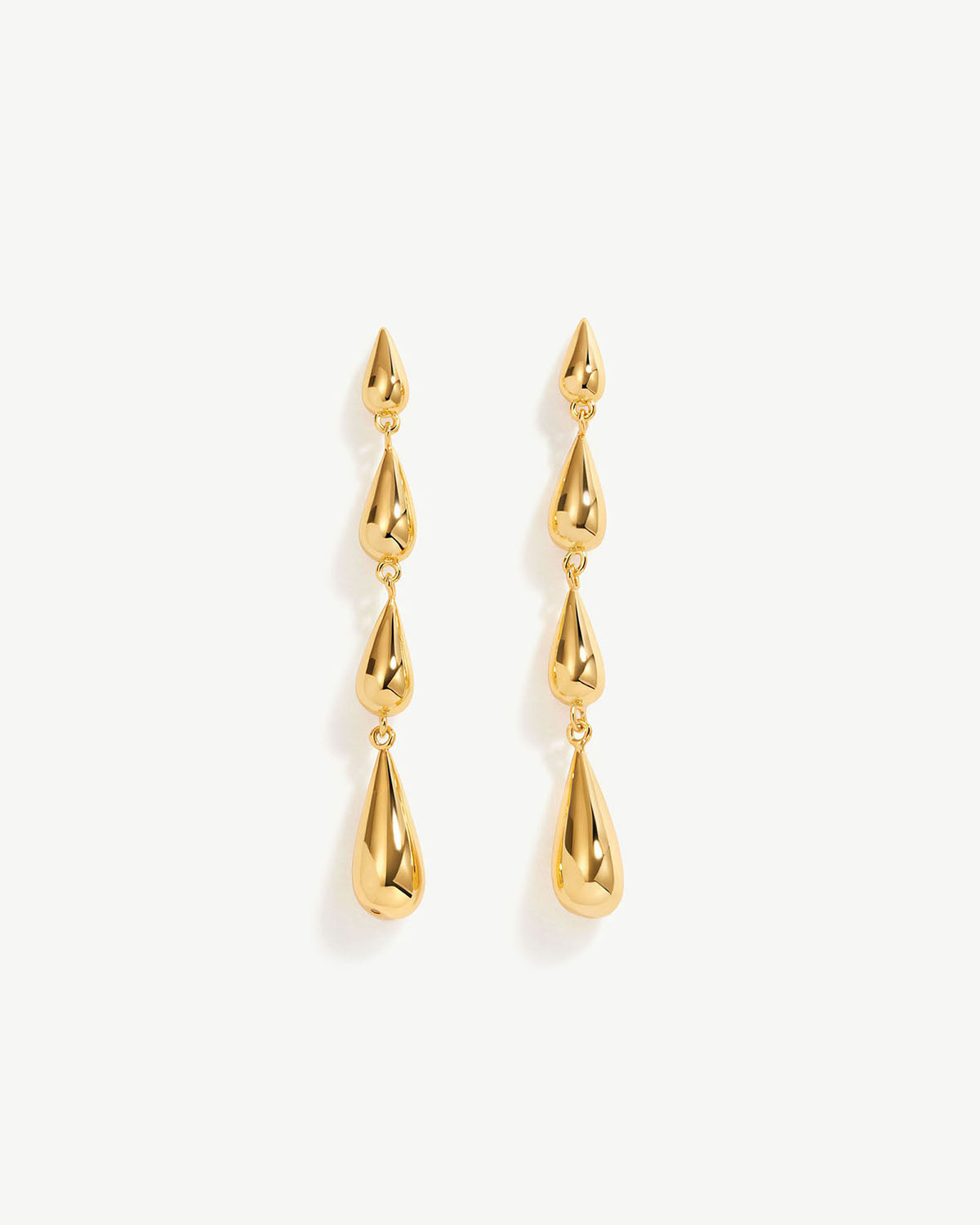 a pair of gold earrings on a white background