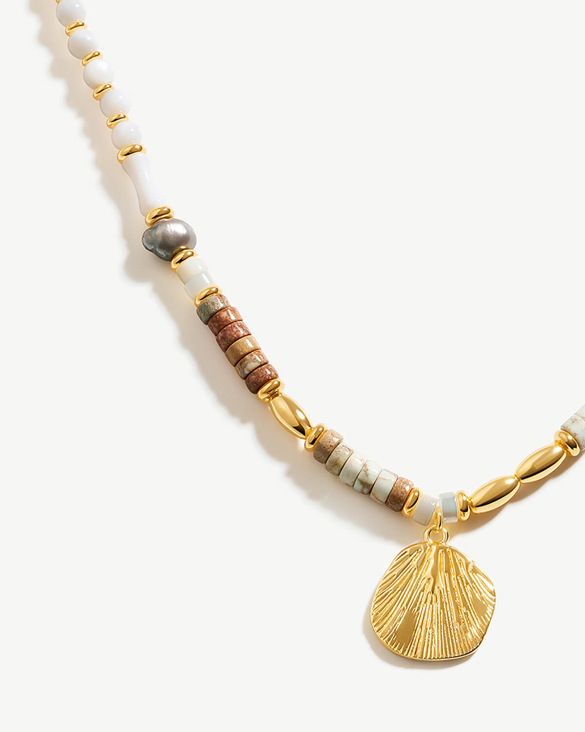 a necklace with a shell charm on a white background