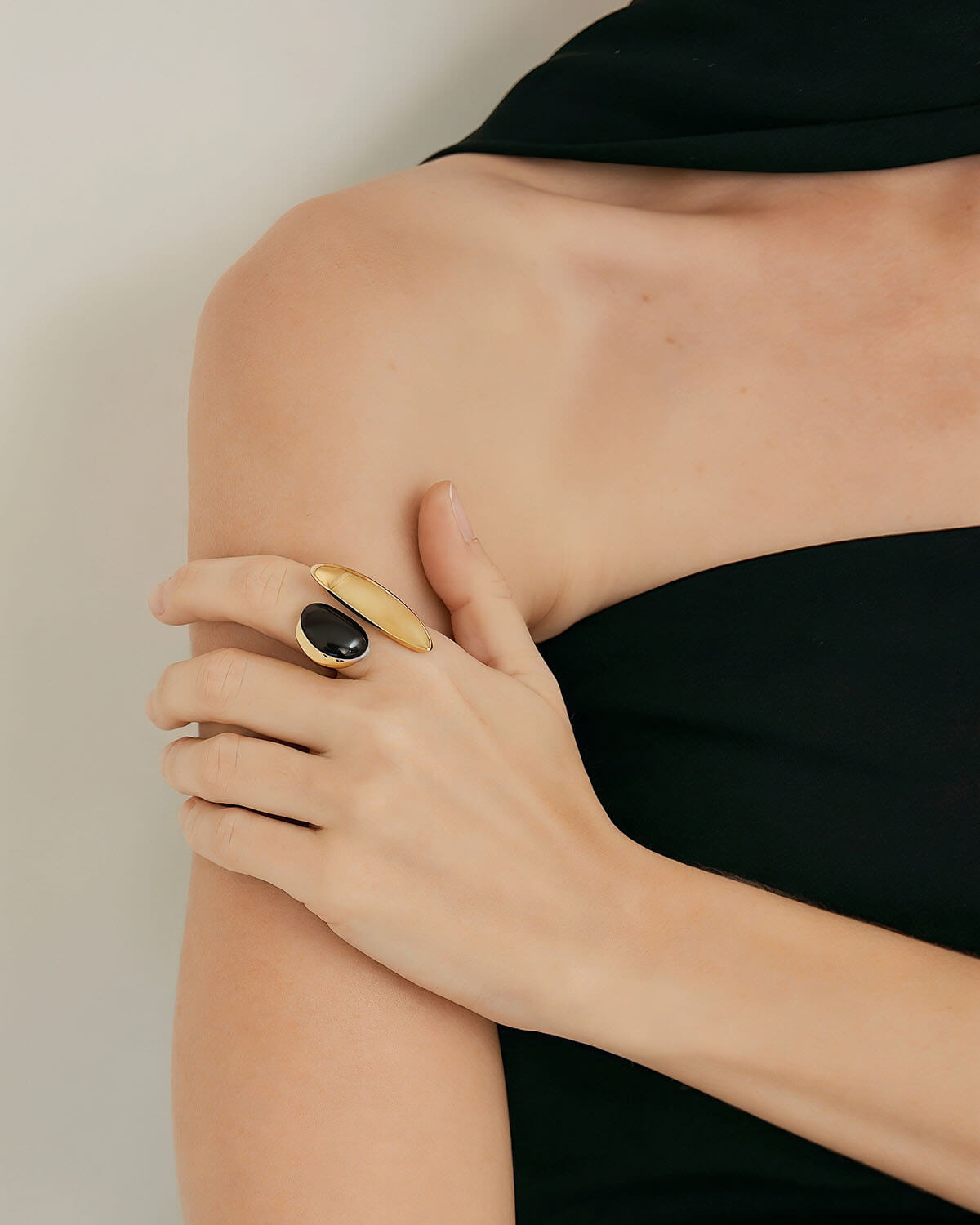 a woman wearing a black dress and a gold ring