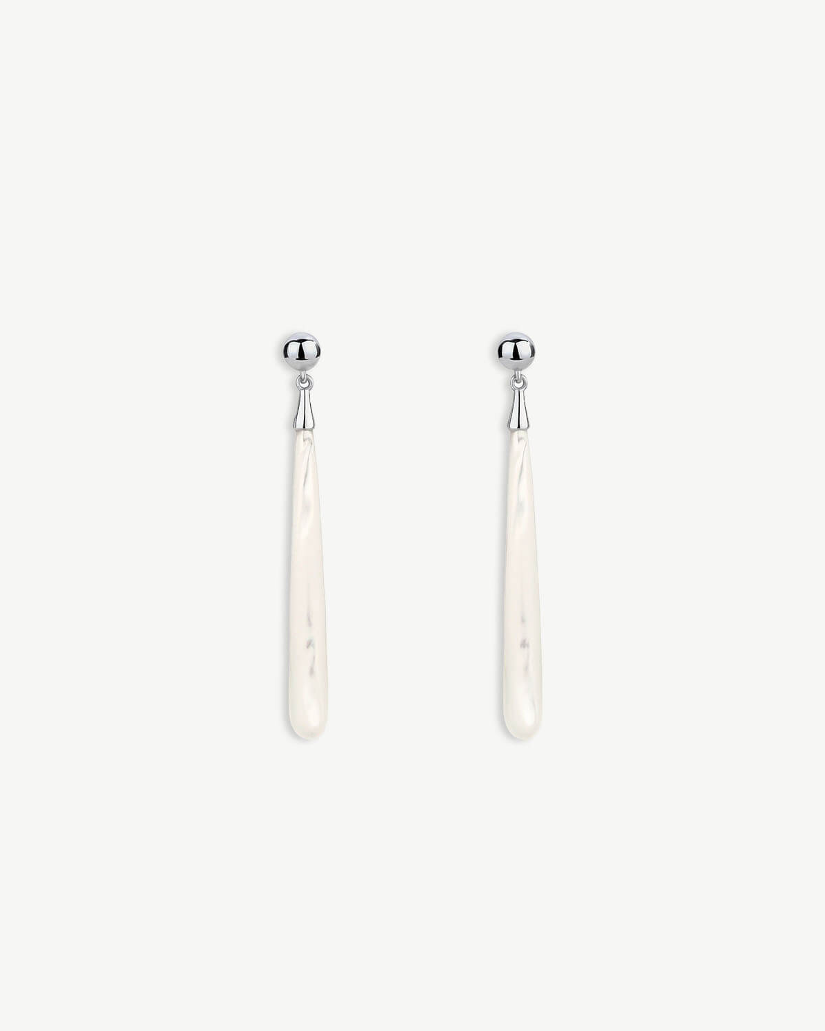 a pair of white earrings on a white background