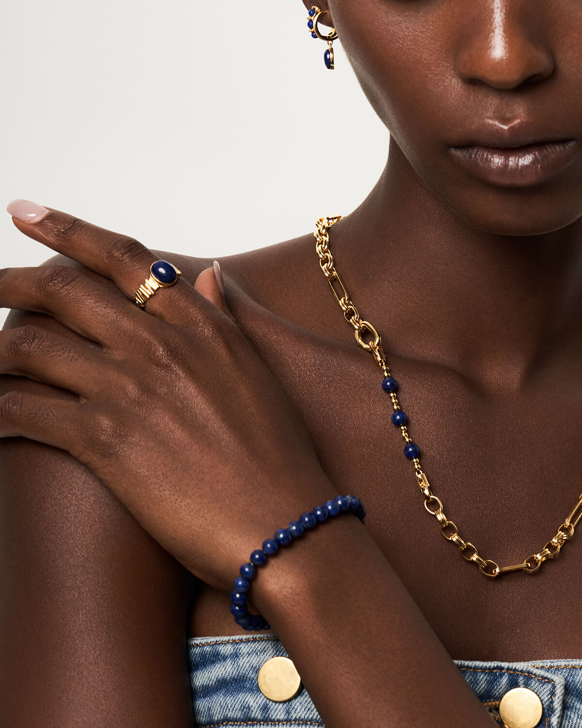 a woman wearing a blue and gold necklace and bracelet