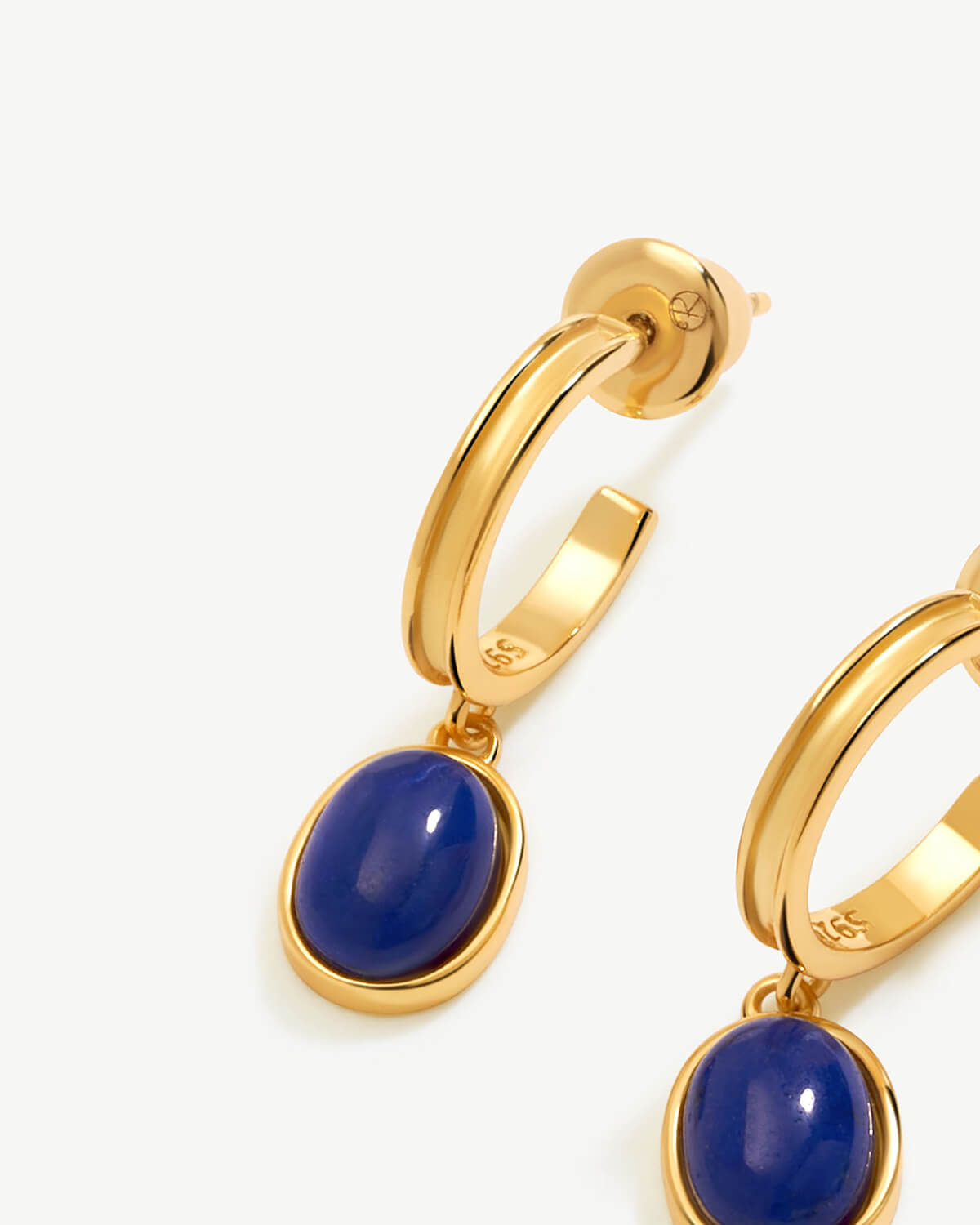 a pair of gold earrings with blue stones