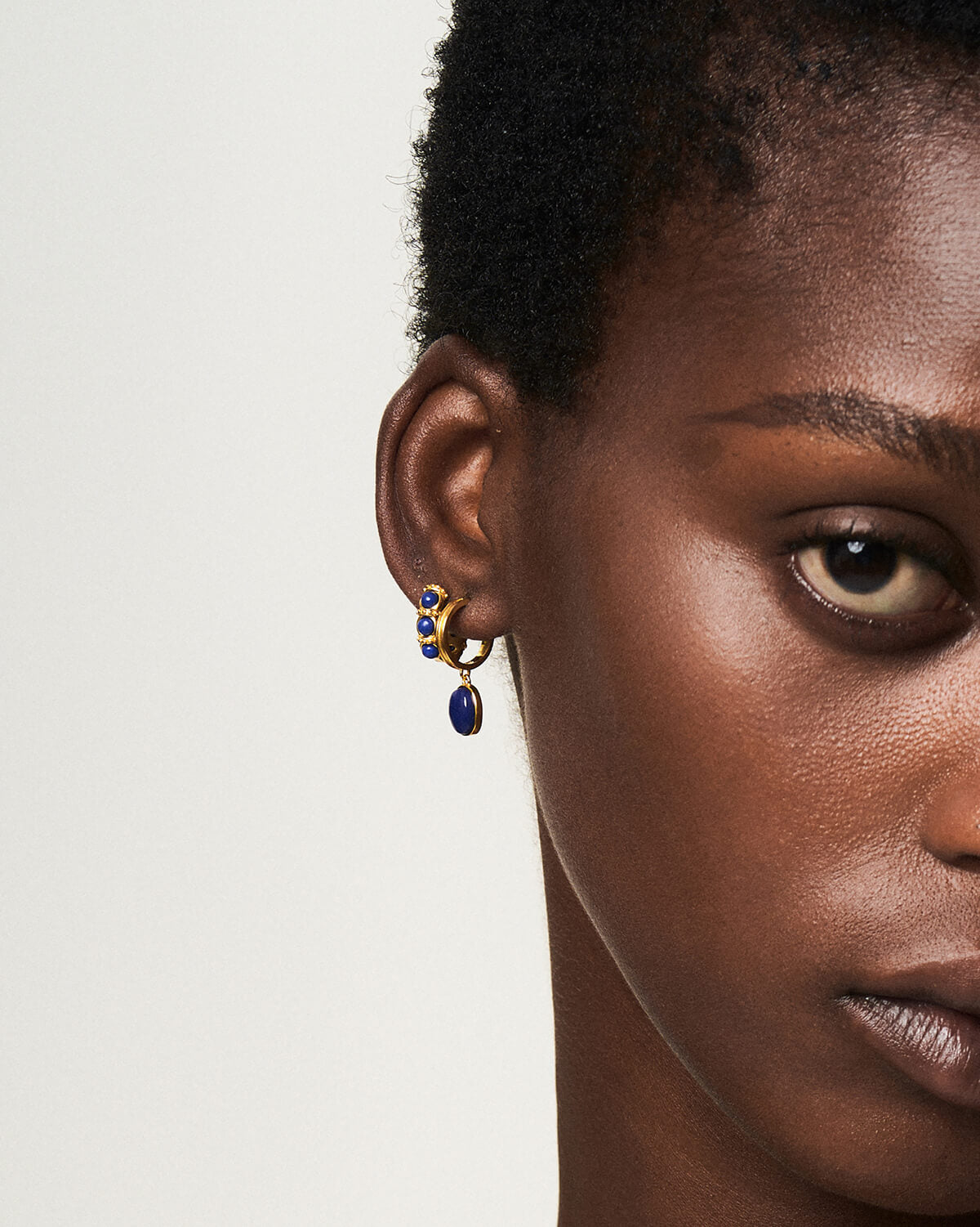 a close up of a person wearing a pair of earrings